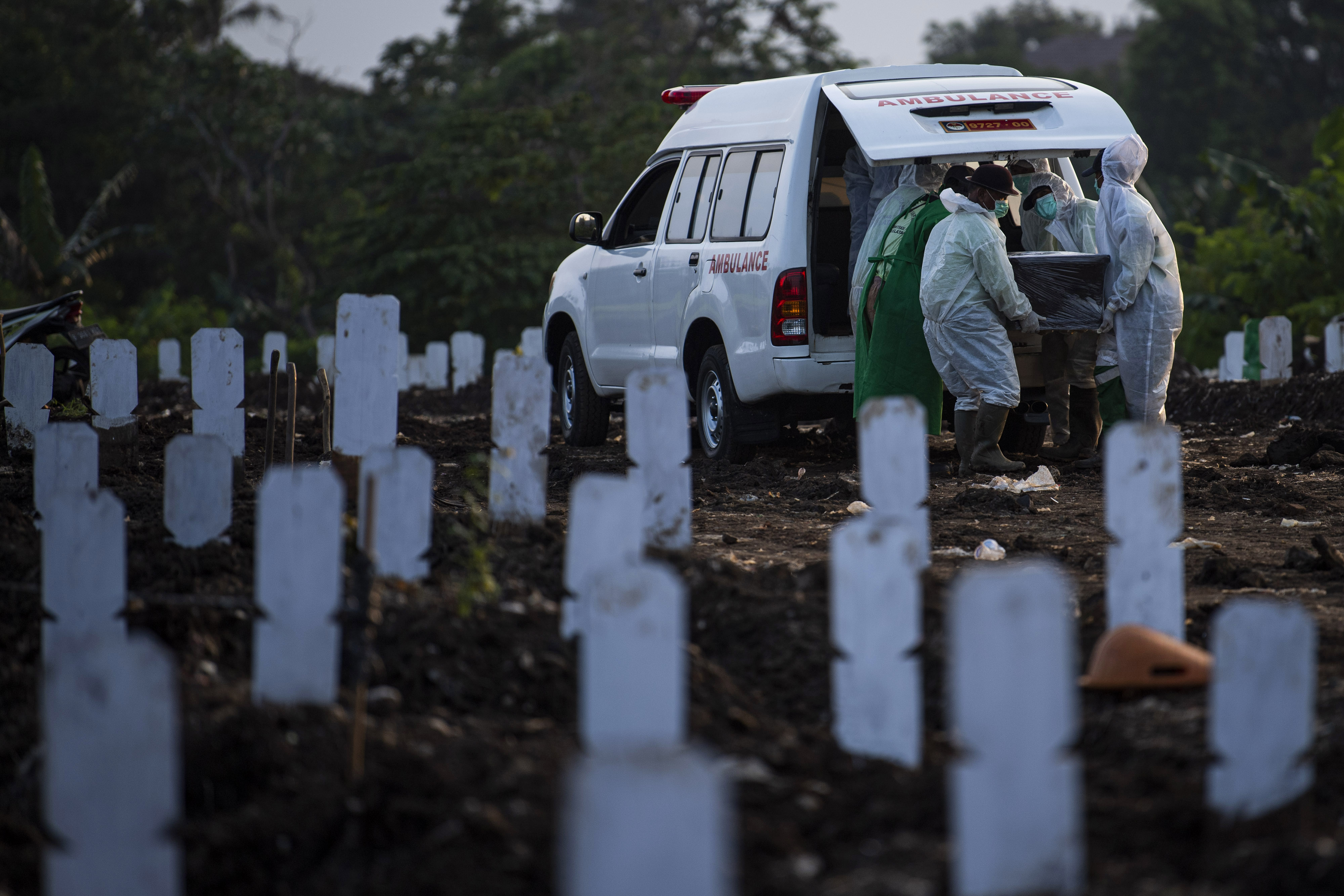 ANGKA KEMATIAN: Petugas membawa peti jenazah korban covid-19 untuk dimakamkan di TPU Srengseng Sawah Dua, Jakarta, Kamis (11/3/2021).