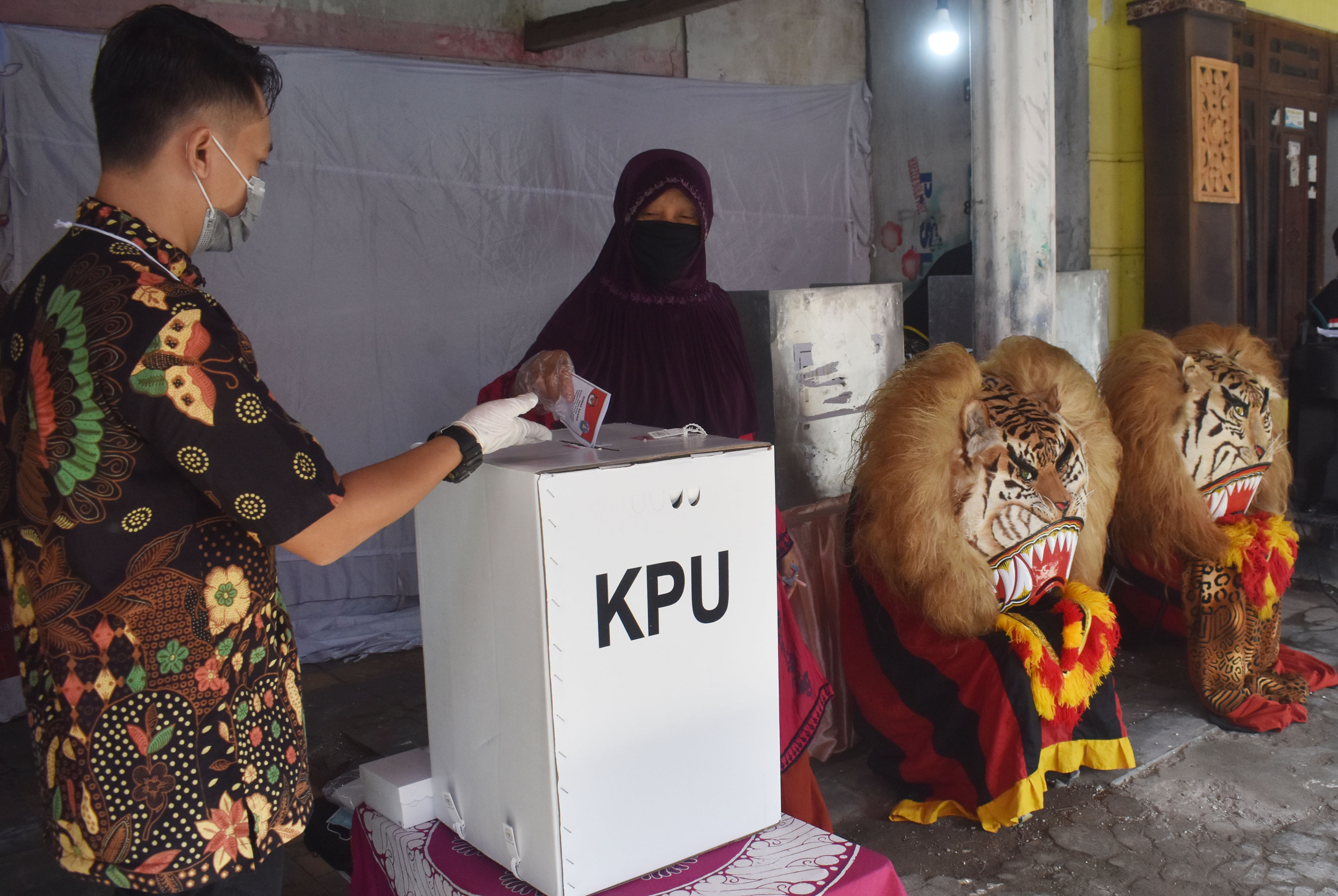 Ilustrasi--Petugas KPPS memandu pemilih memasukkan surat suara ke kotak suara di sebuah TPS di Kabupaten Ponorogo, Jawa Timur.