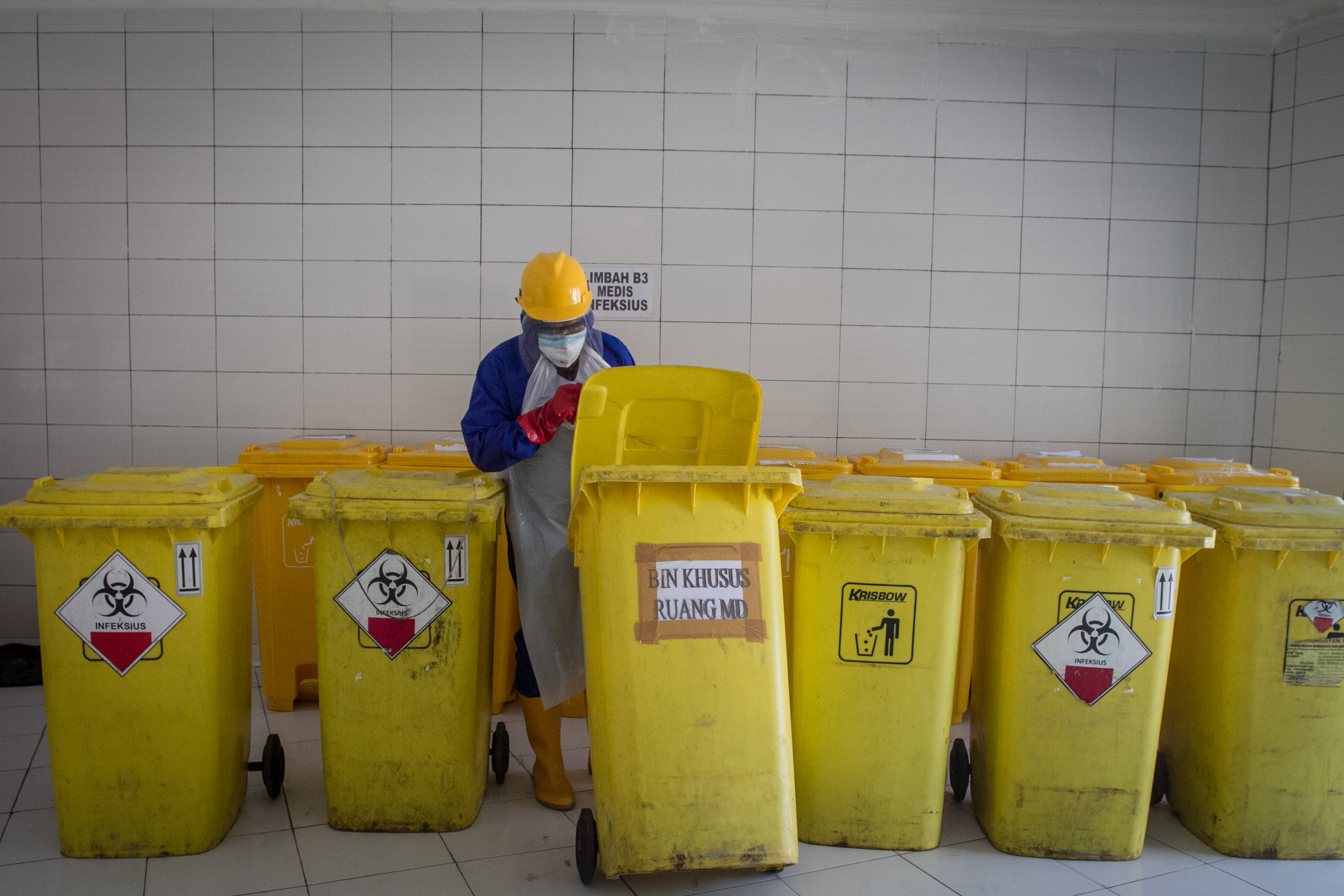 Petugas rumah sakit memeriksa sampah medis sebelum dimasukkan ke mobil jasa pengangkutan.