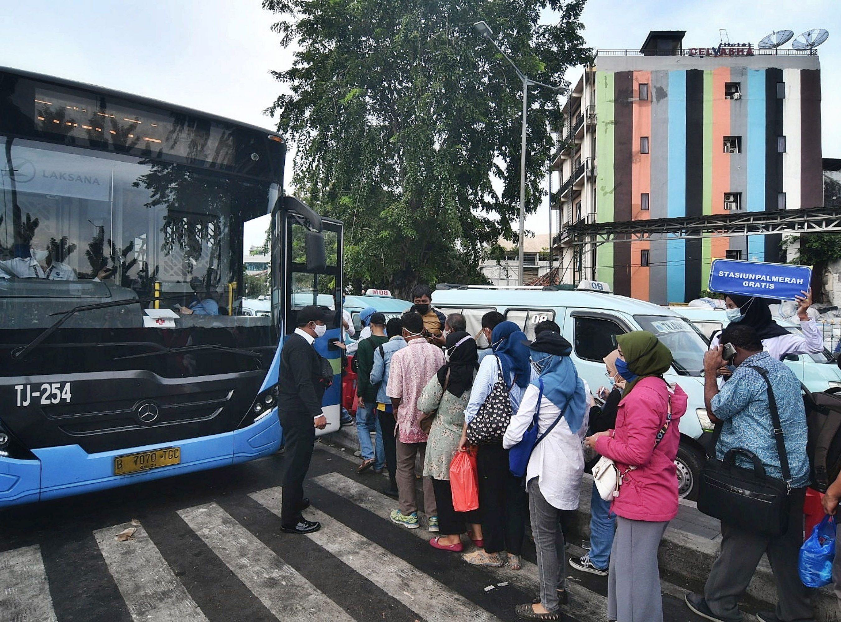 Warga mengantre untuk menaiki bus Transjakarta gratis.