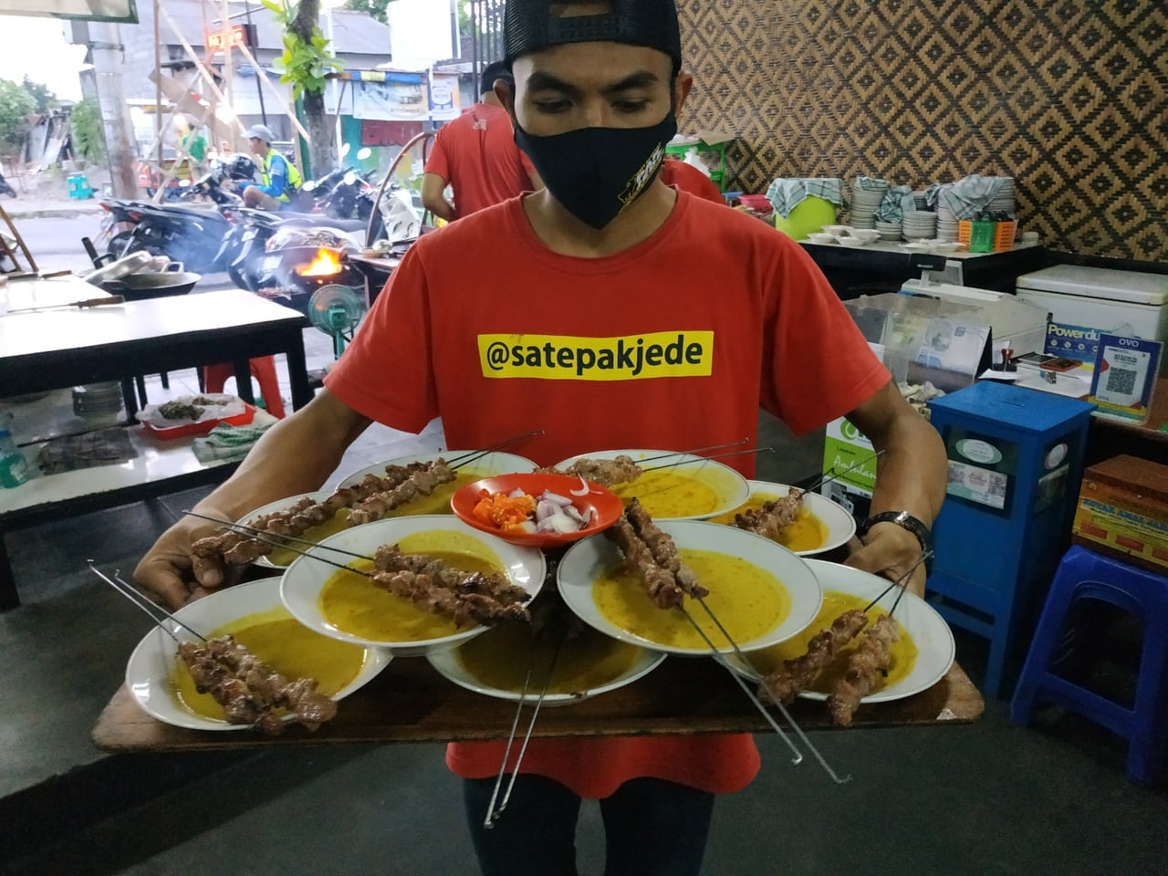 Pelayan membawa pesanan sate klathak