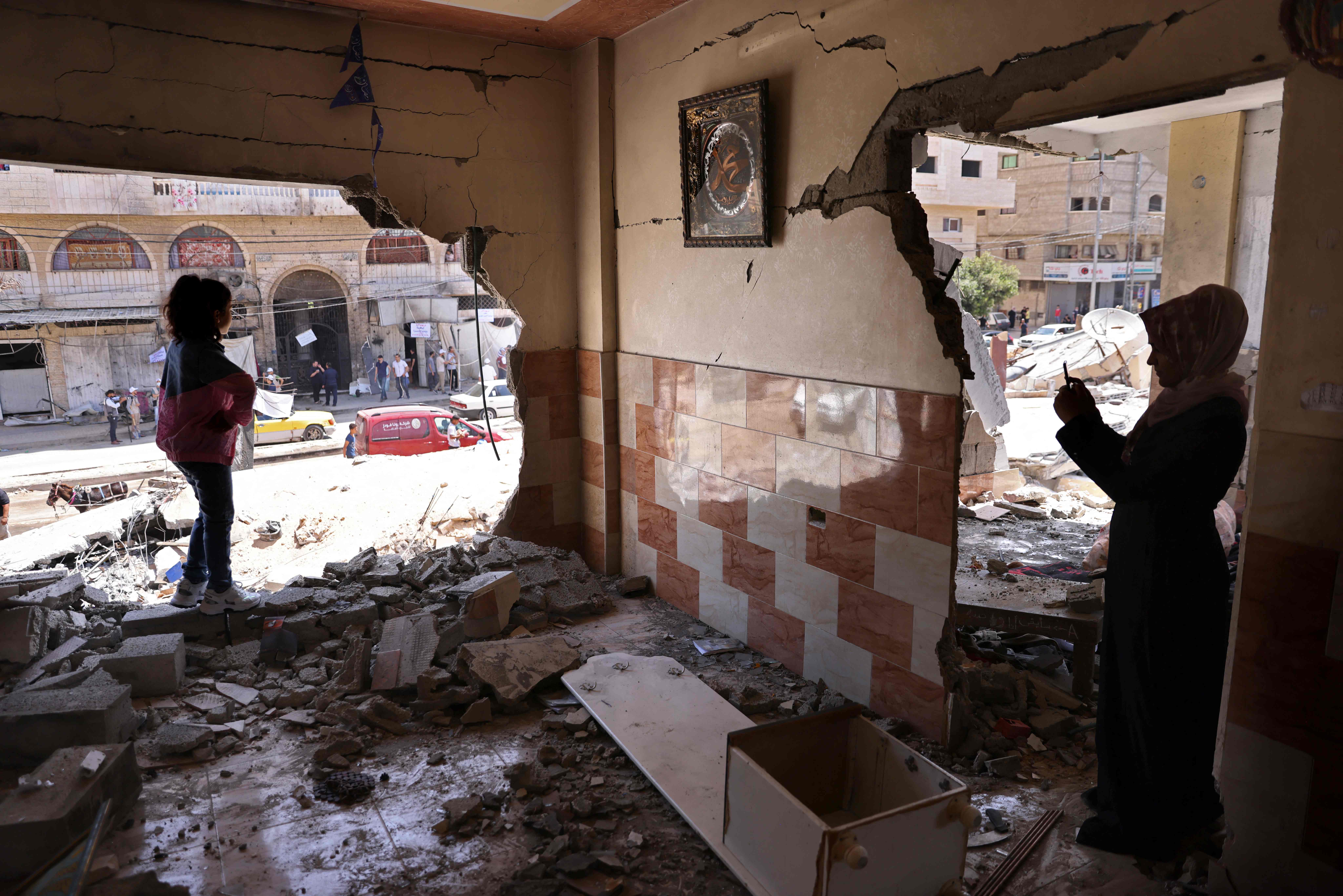 Warga Palestina melihat kondisi rumah mereka yang hancur akibat serangan udara Israel di Gaza City.