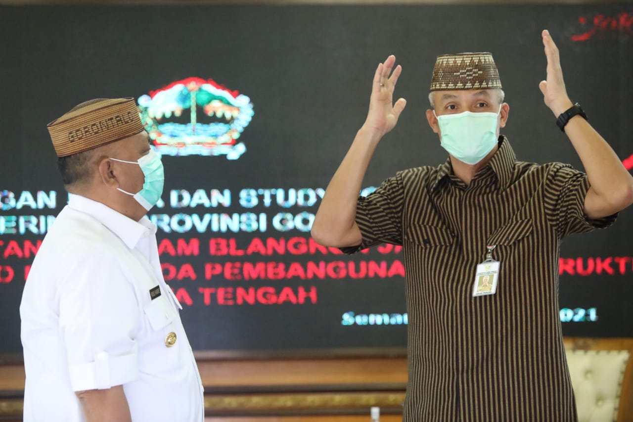 Gubernur Gorontalo Rusli Habibie memberi peci khas buatan Gorontalo kepada Gubernur Jateng Ganjar Pranowo saat pertemuan.  