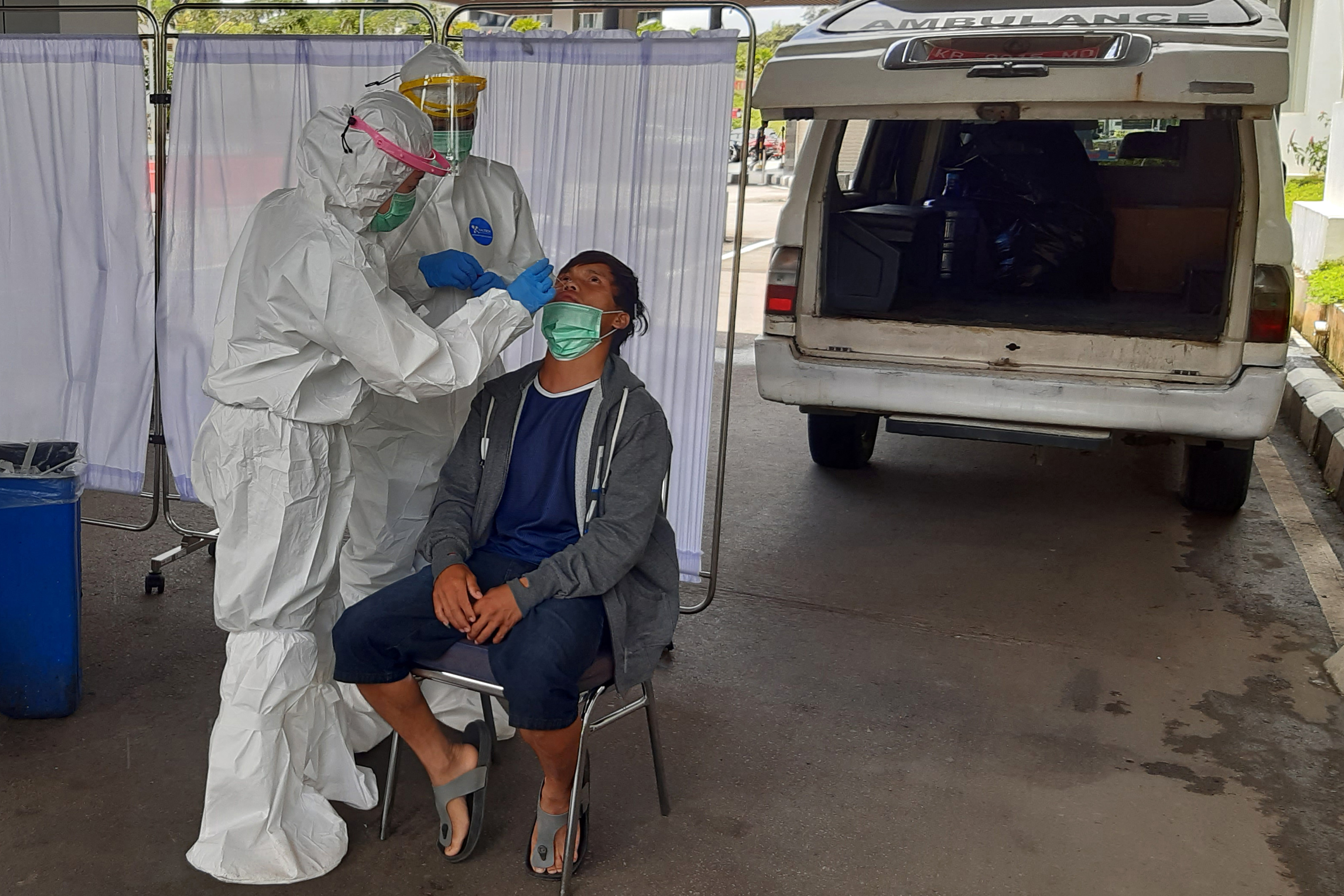 Seorang pekerja migran Indonesia (PMI) dari Malaysia menjalani tes PCR di Entikong, Kabupaten Sanggau, Kalimantan Barat, Rabu (24/3/2021)
