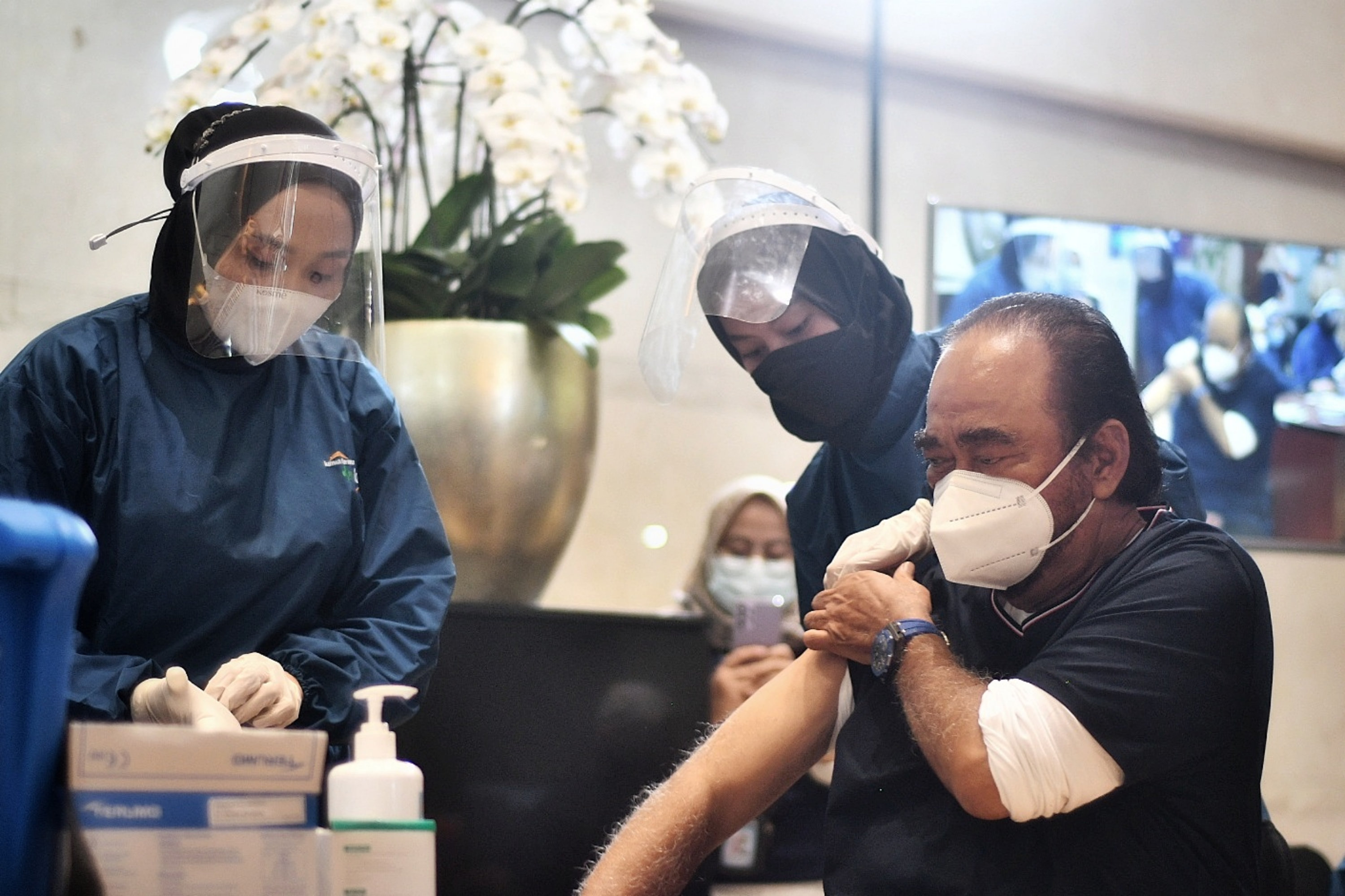Chairman Media Group Surya Paloh menerima suntikan vaksin covid-19 dosis pertama di Lobby Grand Metro TV, Kedoya, Jakarta, Senin (31/5).