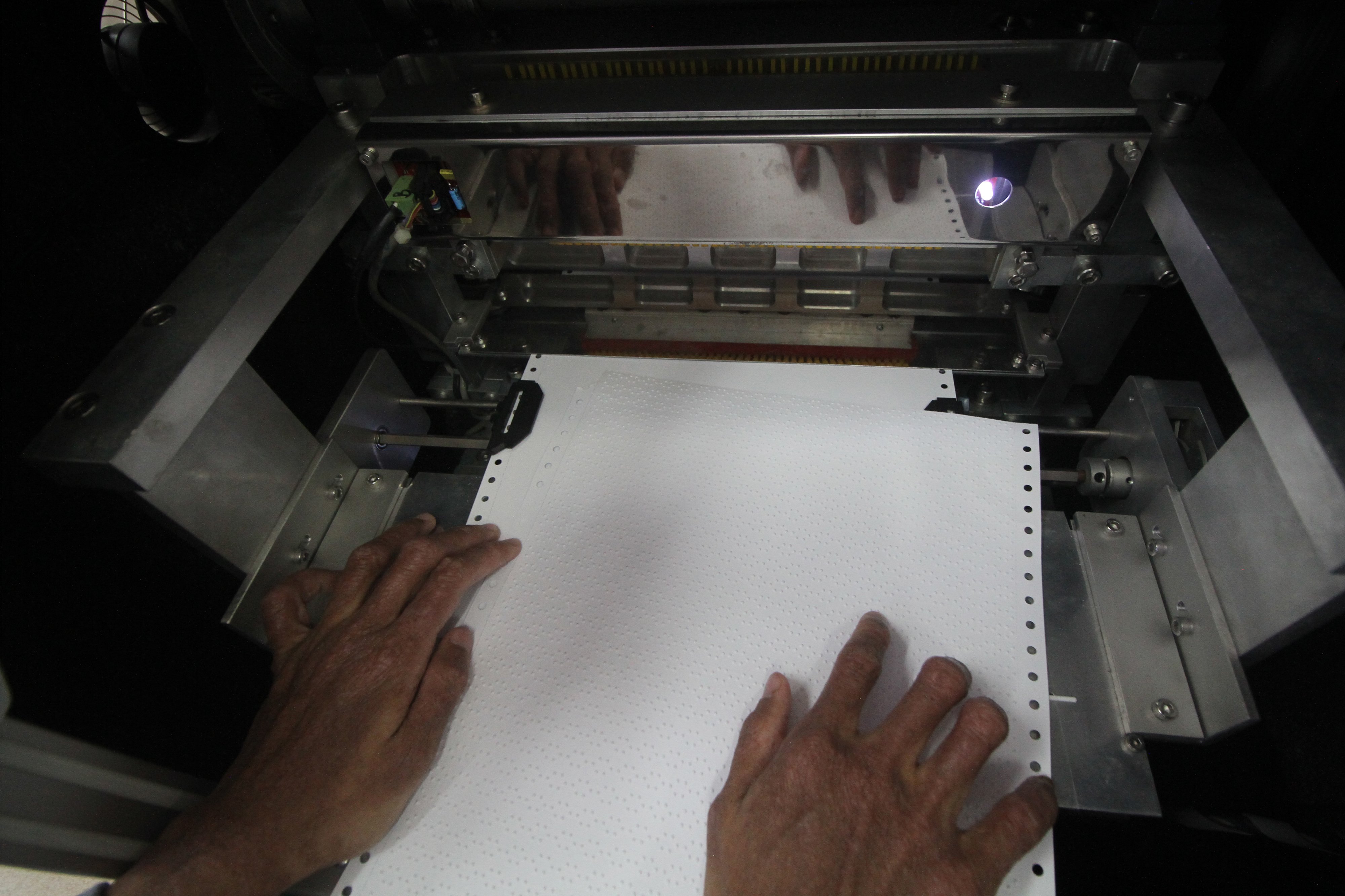 Penyandang disabilitas Rahmat Iqbal meraba cetakan huruf braille dari mesin cetak braille di Gedung Institut Teknologi Telkom di Surabaya. 