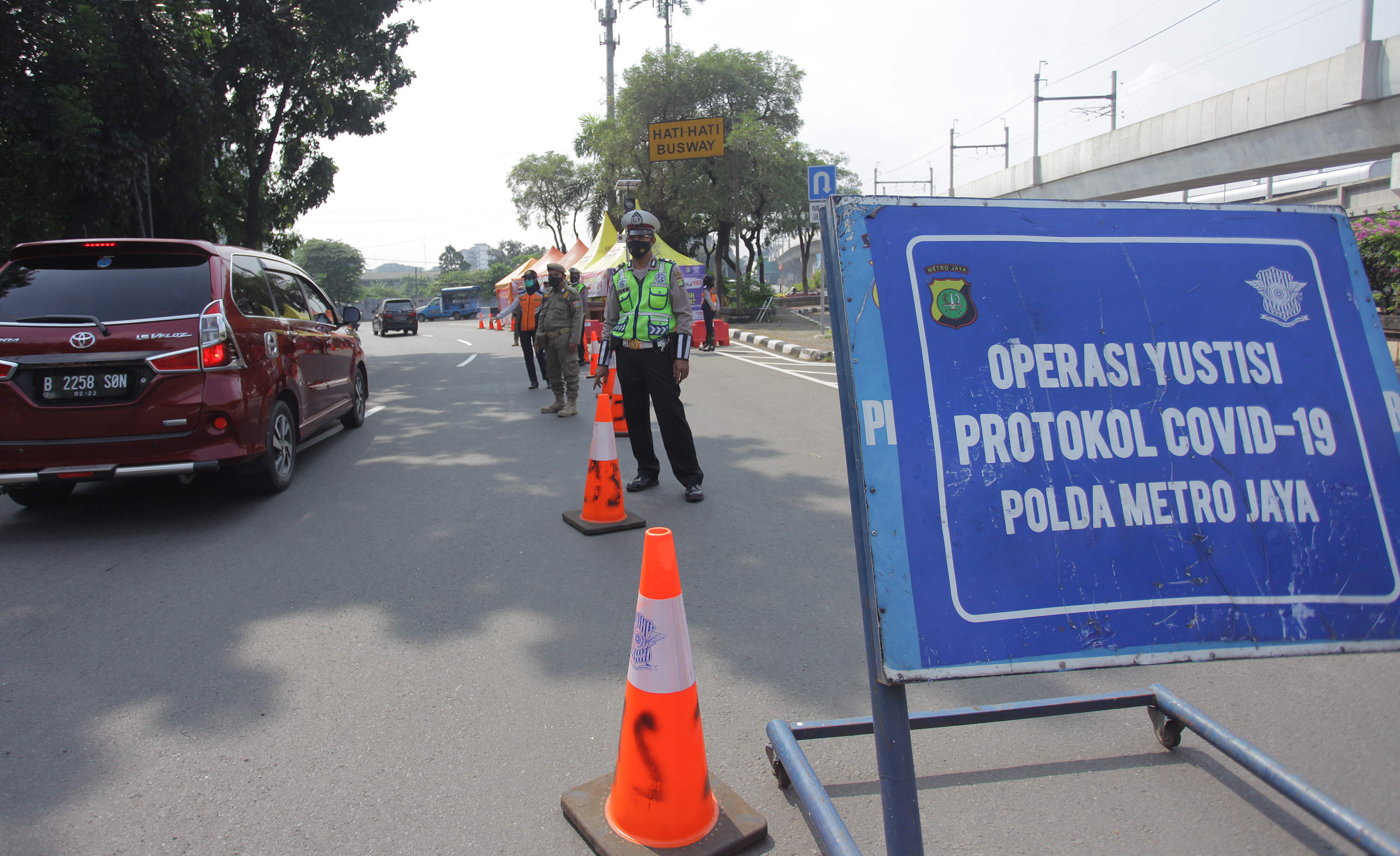Polisi berjaga saat penyekatan larangan mudik Lebaran 2021 di perbatasan pos pemeriksaan sekitar Pasar Jumat, Lebak Bulus, Jakarta.