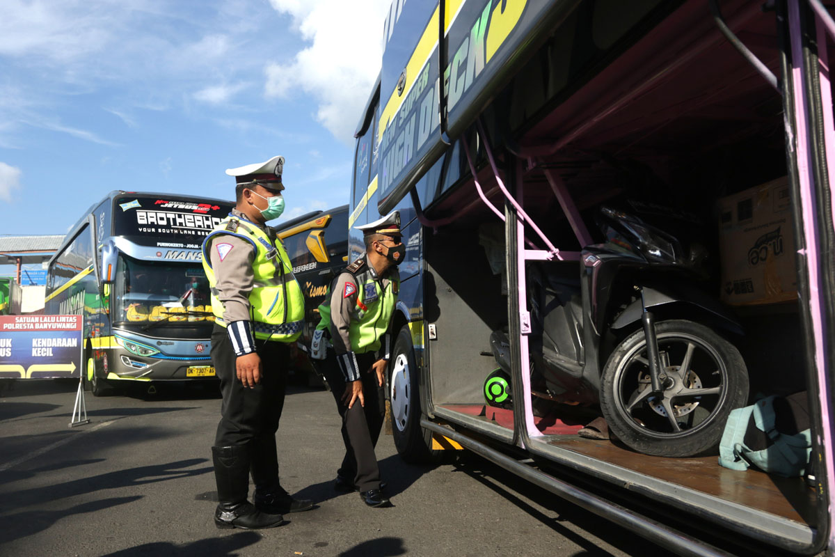 Polisi memeriksa bagasi bus penumpang. 