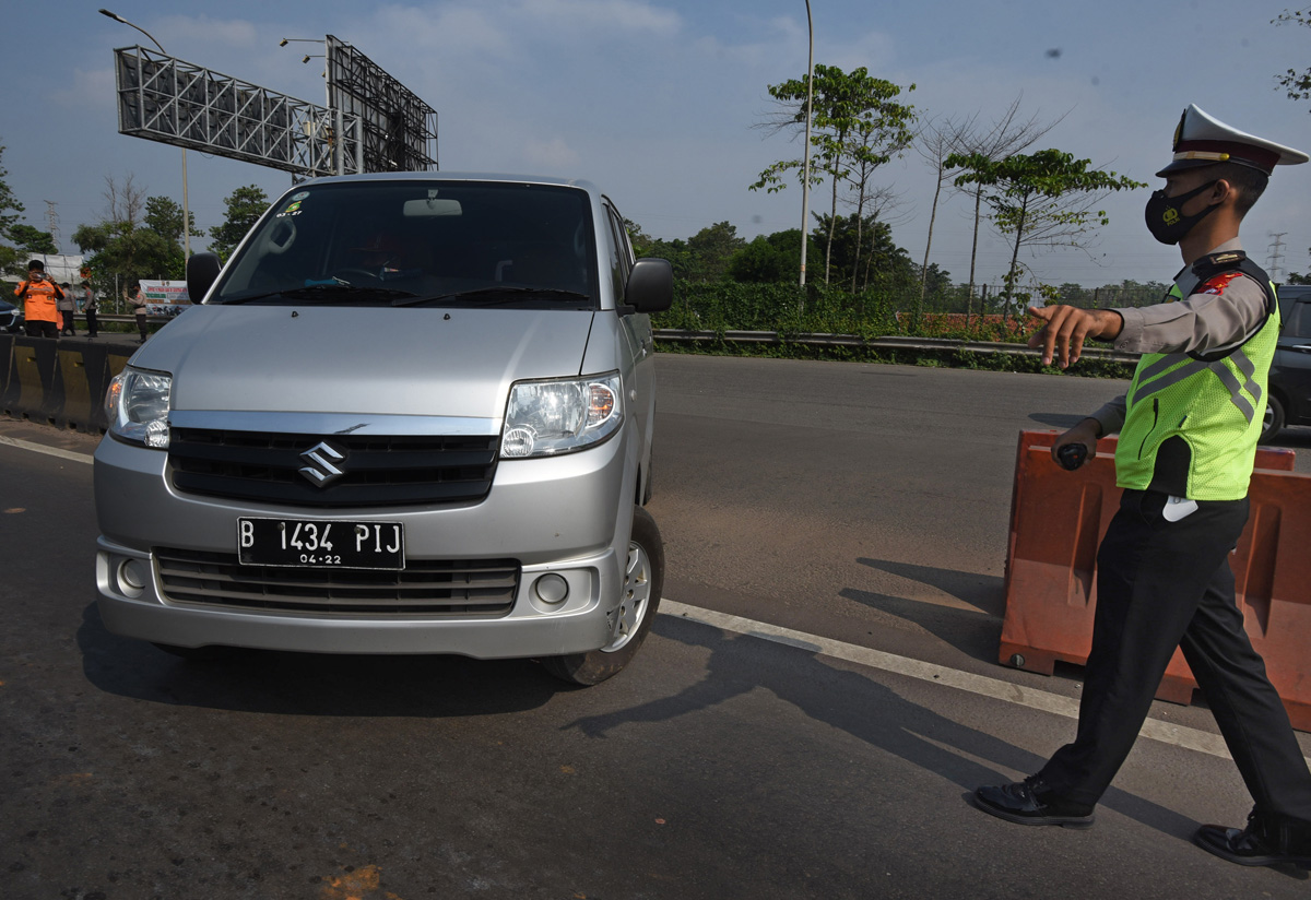 Polisi mengarahkan putar balik kendaraan yang tidak dilengkapi surat izin keluar masuk (SIKM) di pintu Tol Serang Timur, Serang, Jumat (7/5)