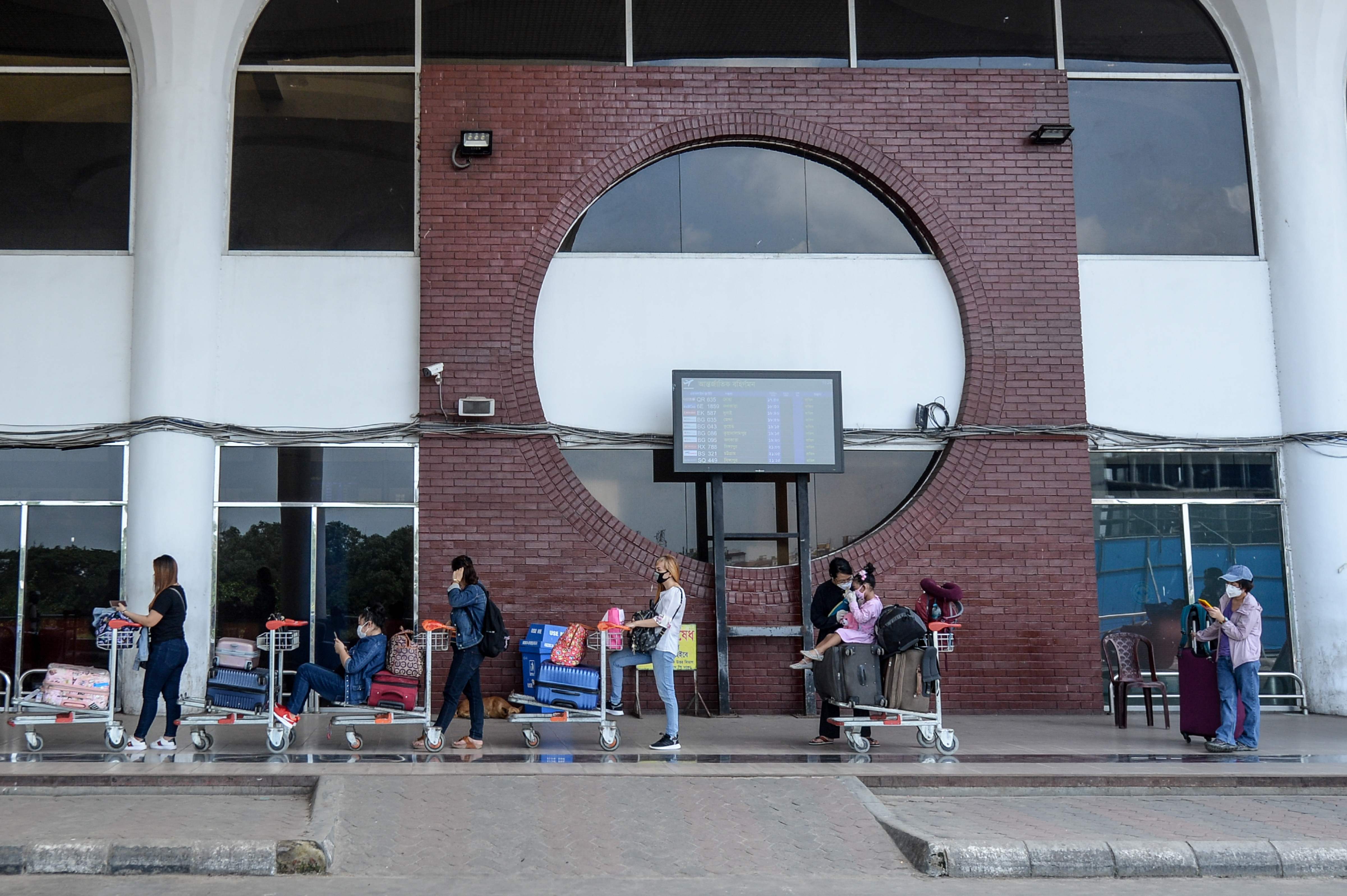 Penumpang mengantre untuk memasuki Bandara Internasional Hazrat Shahjalal di Dhaka, Bangladesh.