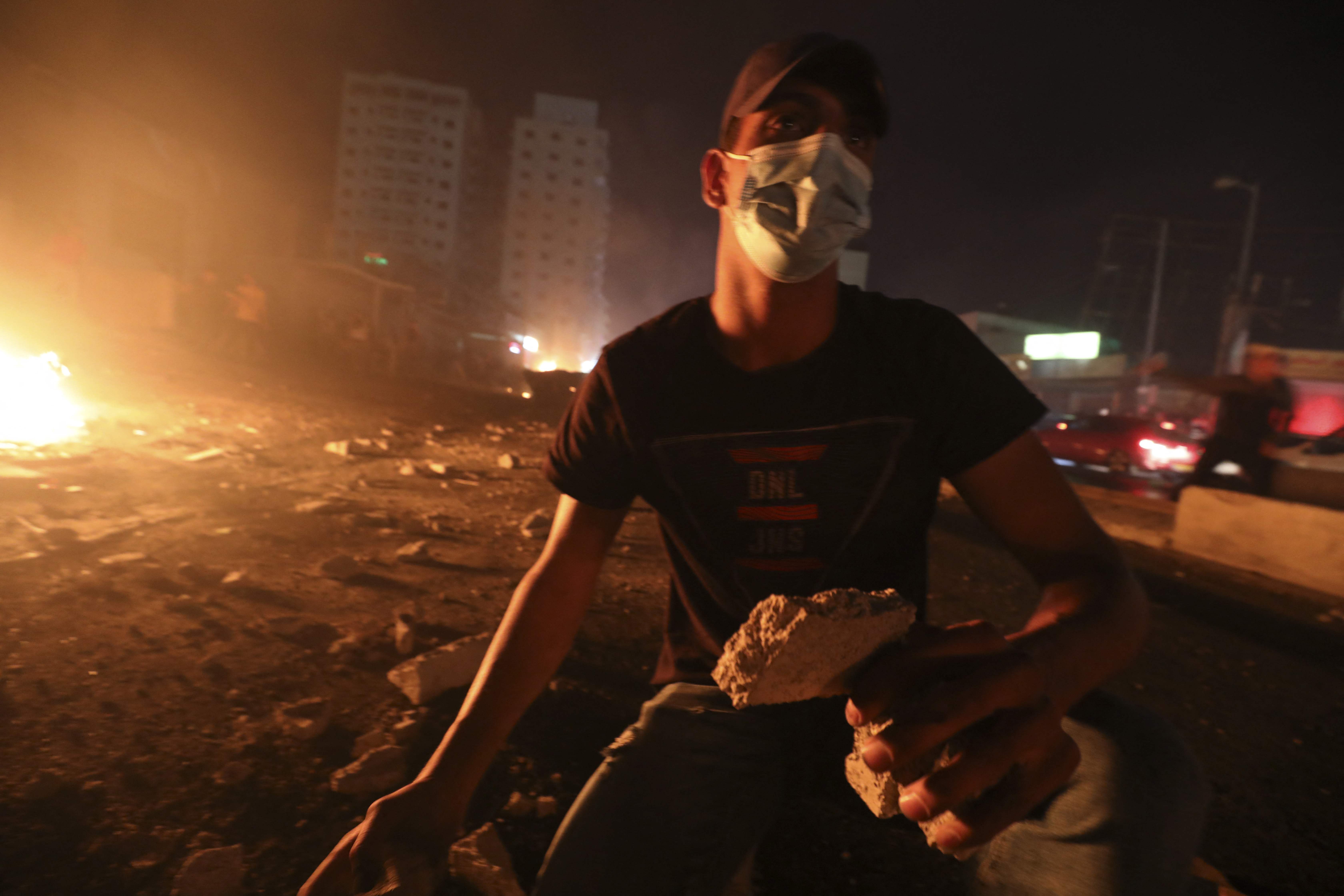 Warga Palestina melemparkan batu ke arah polisi Israel di Jerusalem.