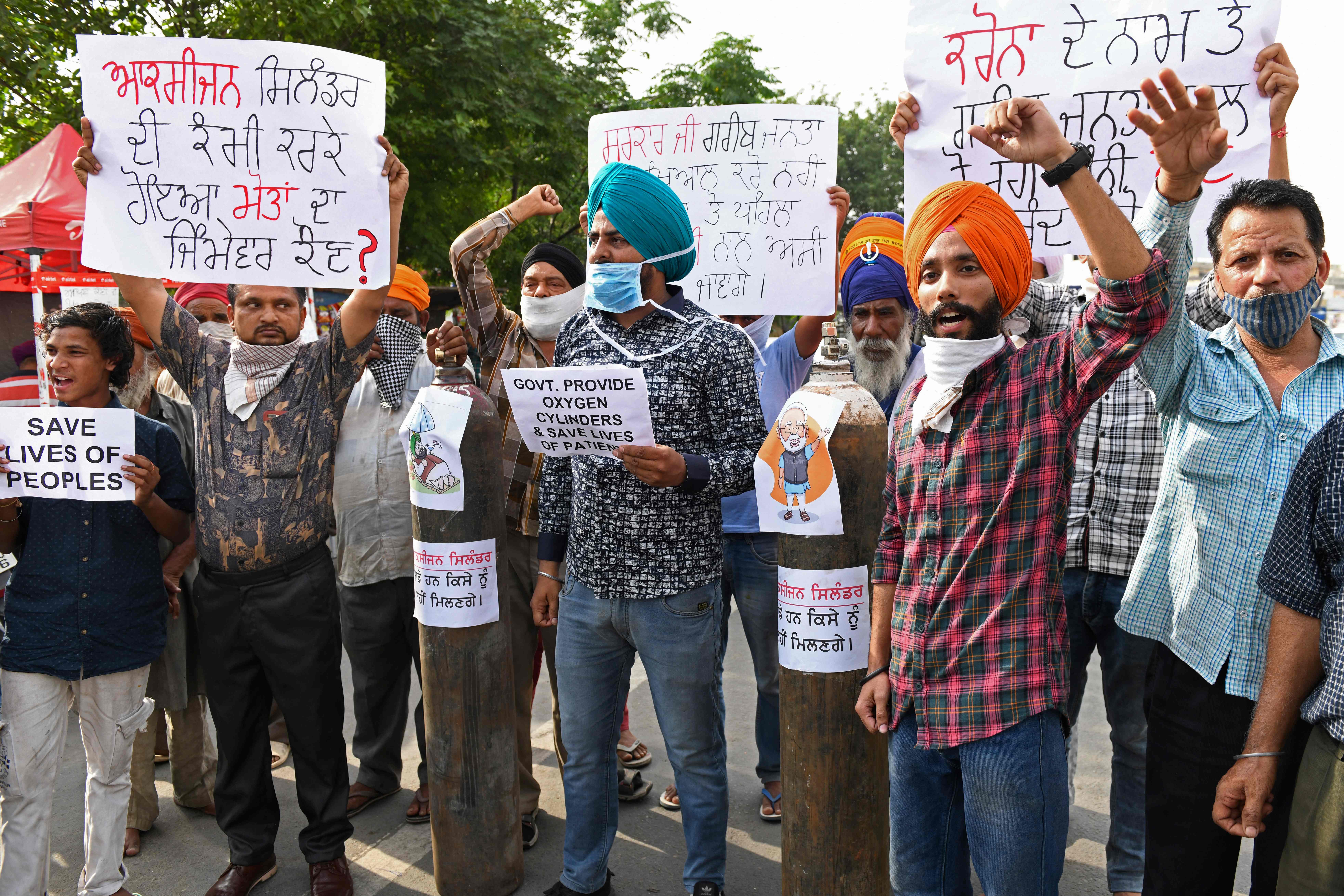 Para demonstran memprotes soal kekurangan tabung oksigen bagi pasien Covid-19 di Amritsar, India, Jumat (30/4).