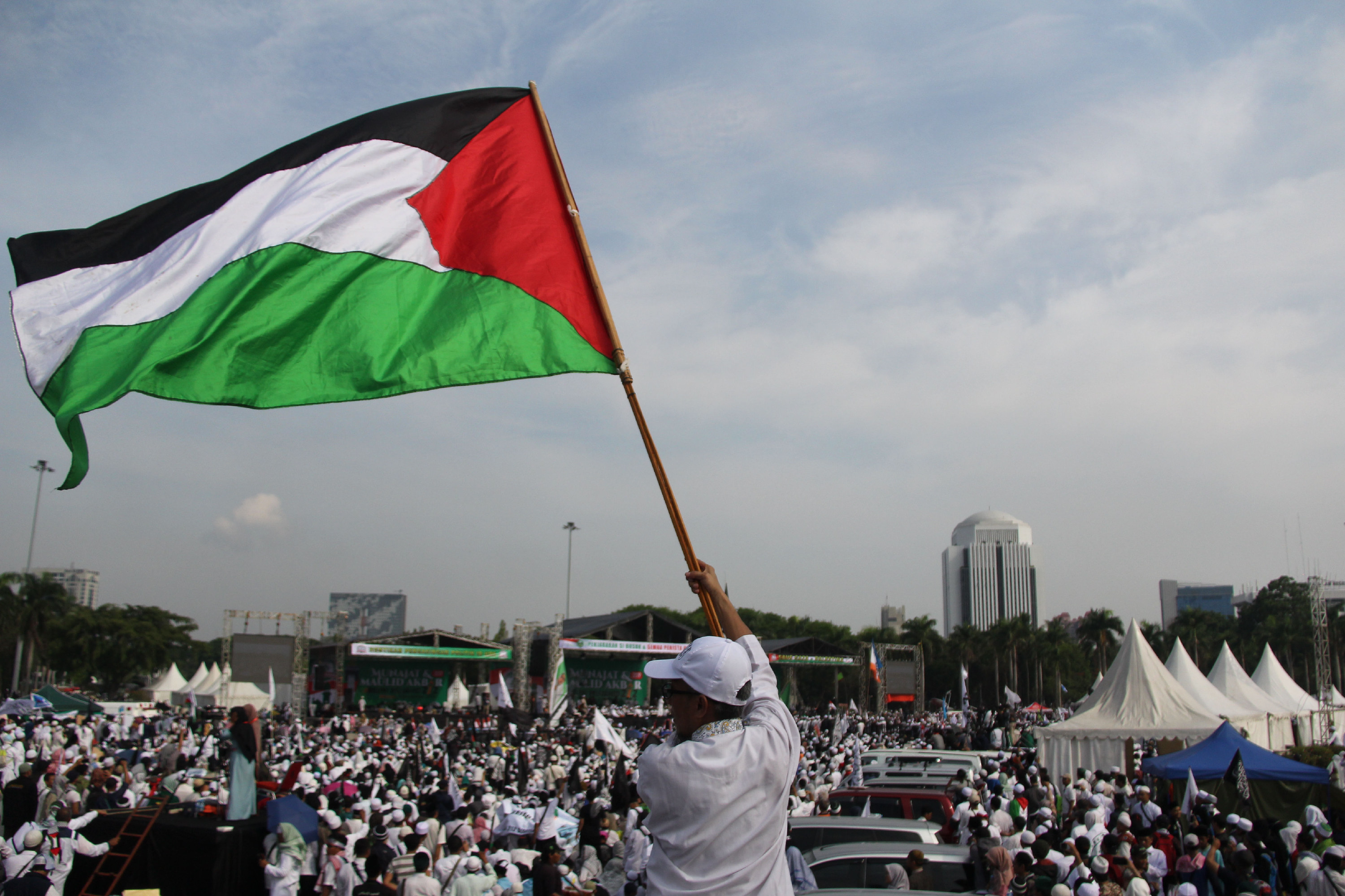  Peserta aksi membentangkan bendera Palestina di tengah-tengah masa yang tergabung dalam reuni 212 di kawasan Monas, beberapa waktu lalu.