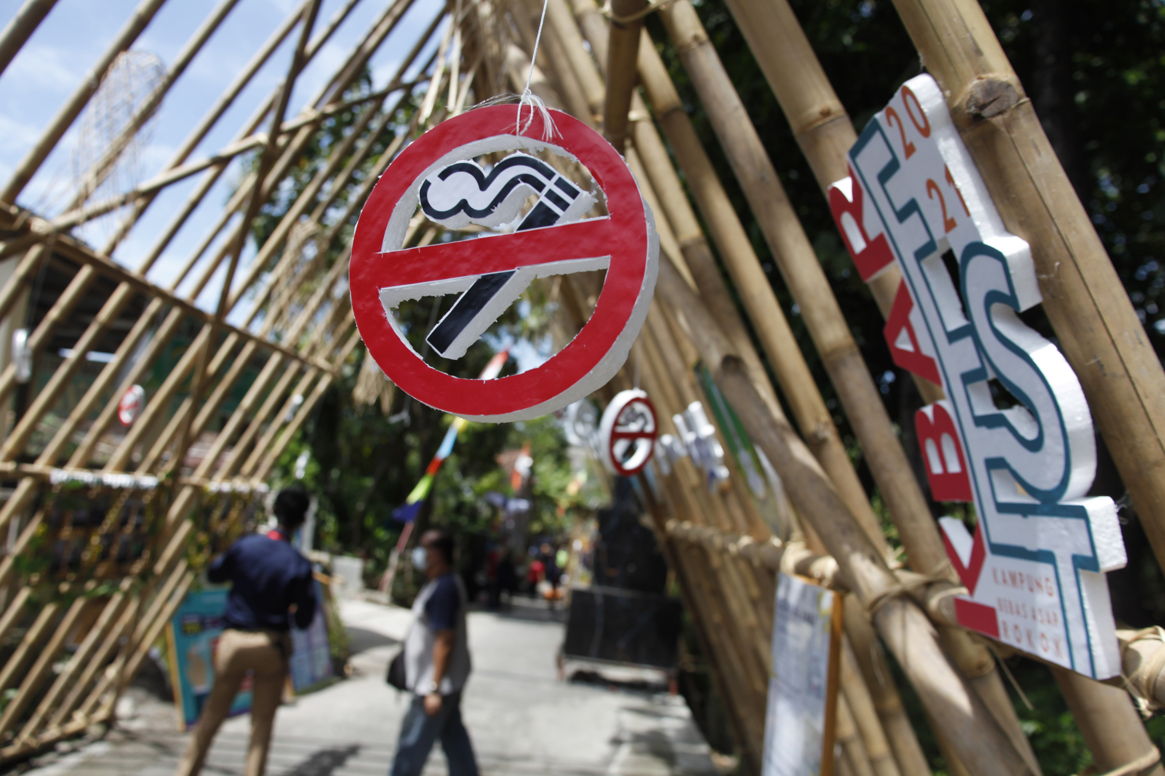  Warga melihat sejumlah poster edukasi kesehatan pada Festival Model Kampung Bebas Asap Rokok di Mojosongo, Solo, Rabu (24/3/2021).
