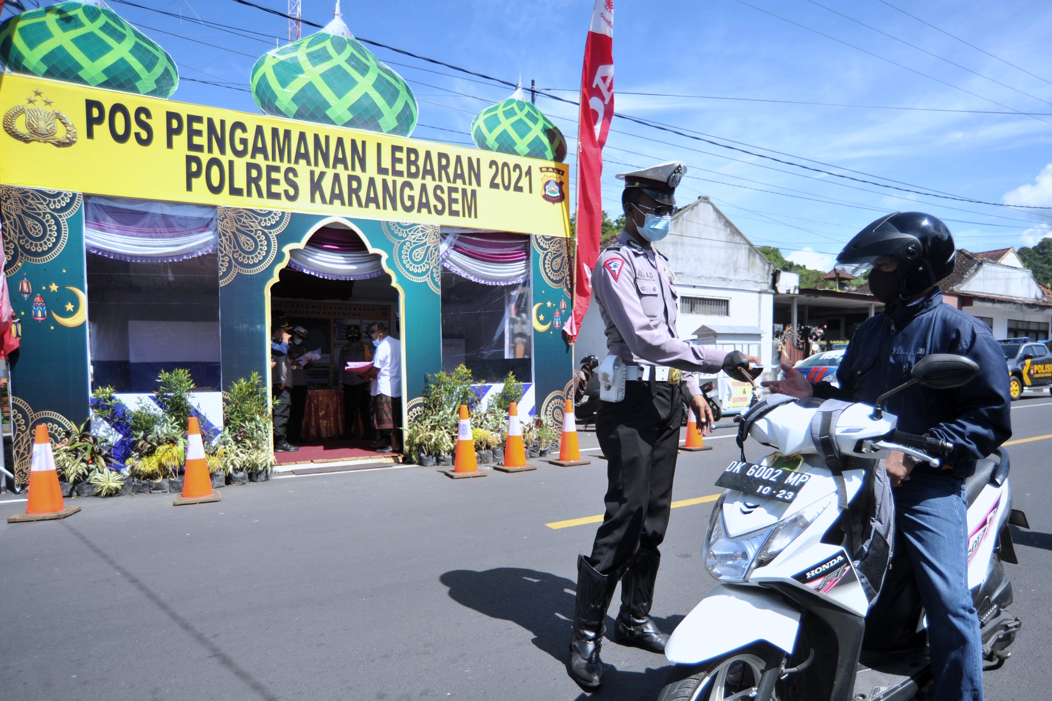 Petugas memeriksa identitas pengendara saat hari pertama penyekatan mudik Lebaran di Pos Penyekatan Padangbai, Bali, Kamis (6/5).