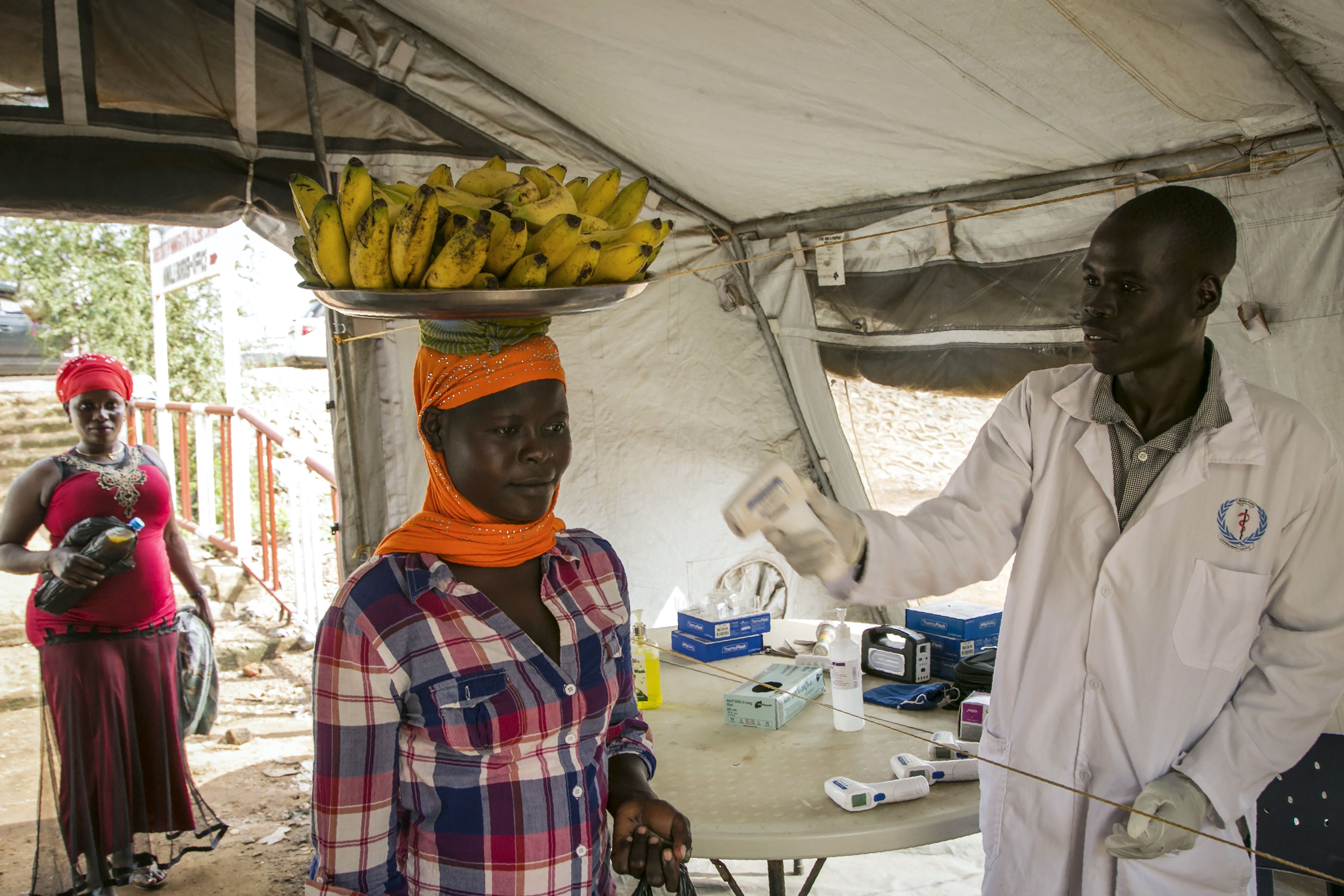 Petugas kesehatan memeriksa suhu tubuh warga yang melintas dari Sudan Selatan menuju Uganda.