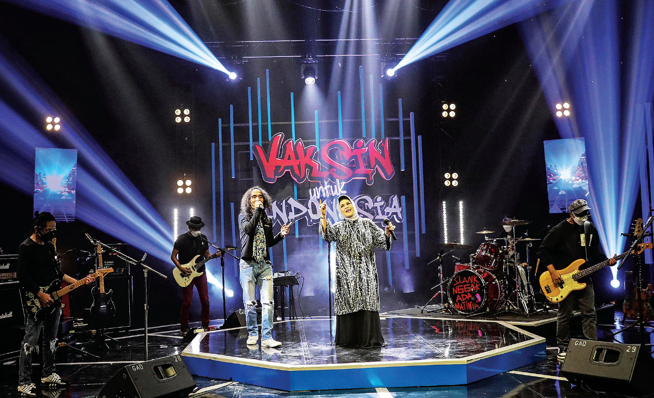 Vokalis grup Slank, Kaka, bernyanyi bersama dengan penyanyi senior serbabisa, Hetty Koes Endang, dalam program Vaksin Slank untuk Indonesia.