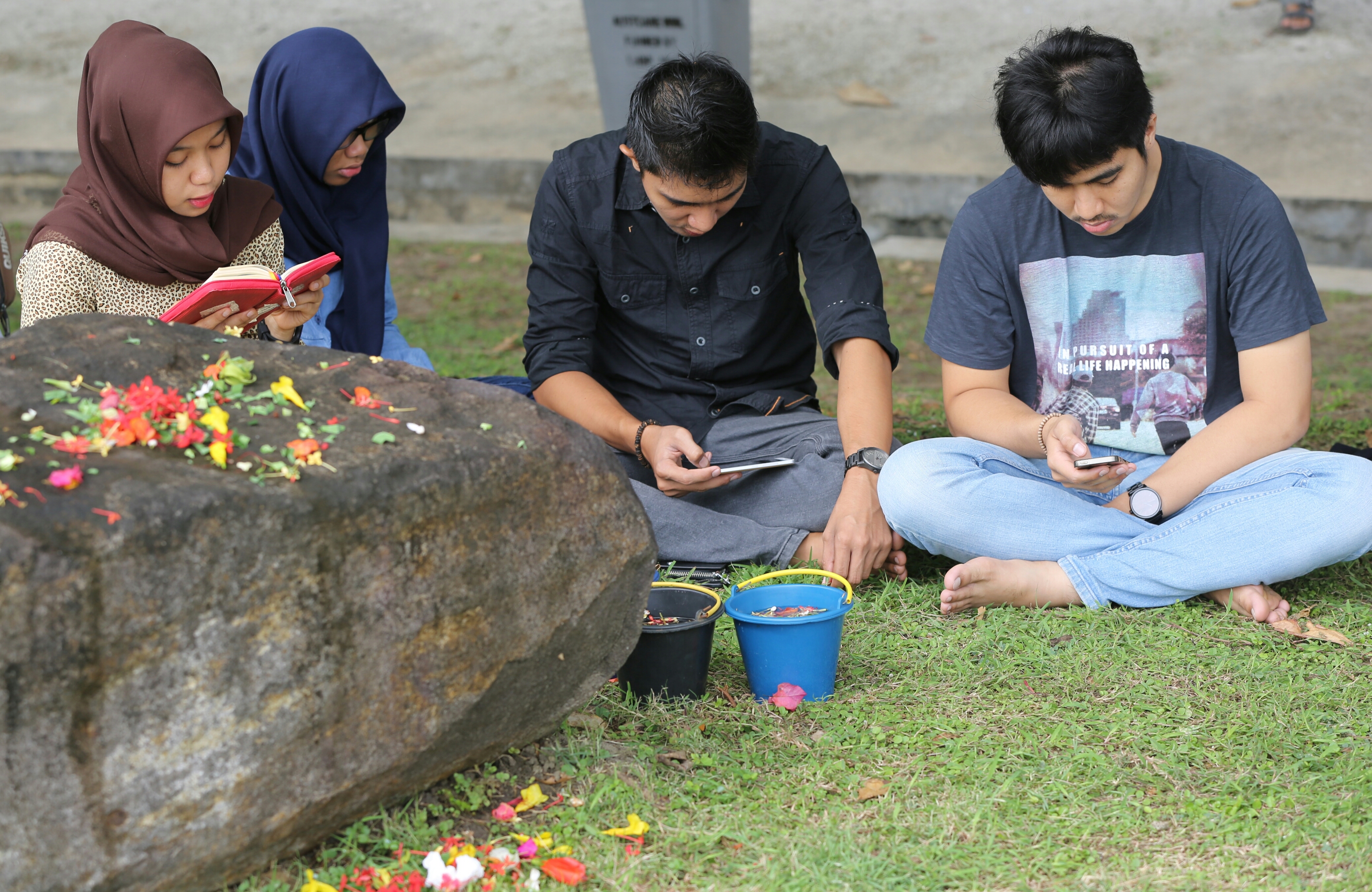 Warga sedang berdoa di lokasi kuburan masal korbsn tsunami Aceh, Kawasan Ulee Lheue, Kecamatan Meuraxa, Banda Aceh