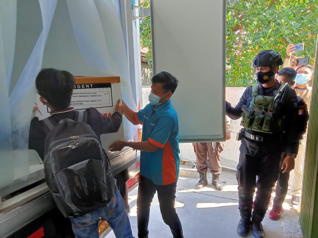 Sejumlah petugas menurunkan vaksiin dari atas truk untuk warga Kalimantan Tengah
