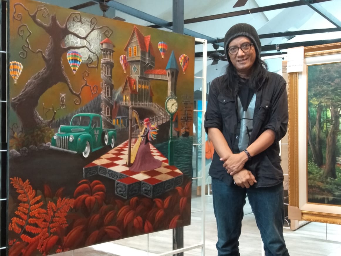 Tommy Karmawan di samping karya lukisannya yang dipamerkan di Plaza Semanggi Jakarta 
