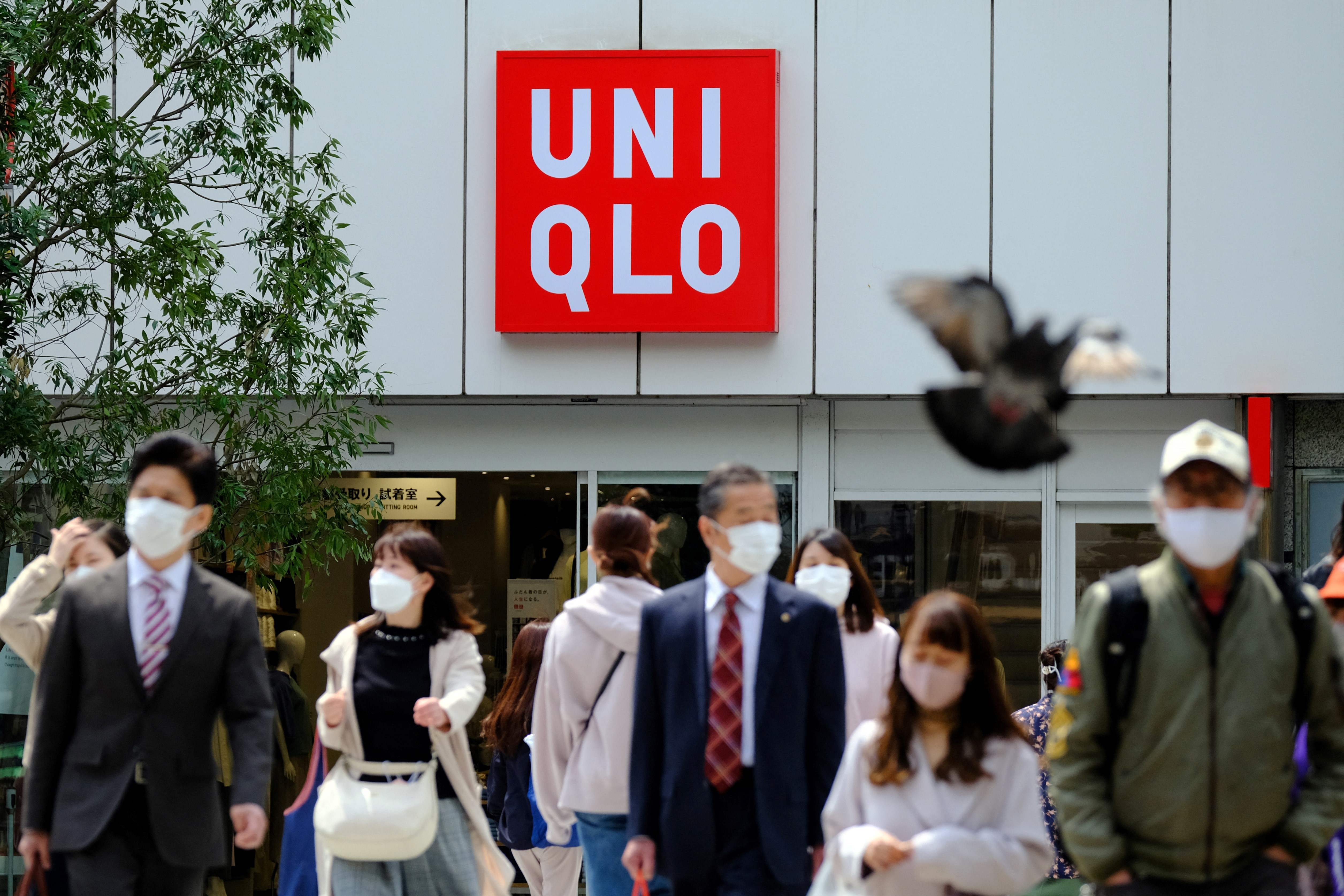 Pejalan kaki melintas di depan toko Uniqlo di Tokyo, Jepang.