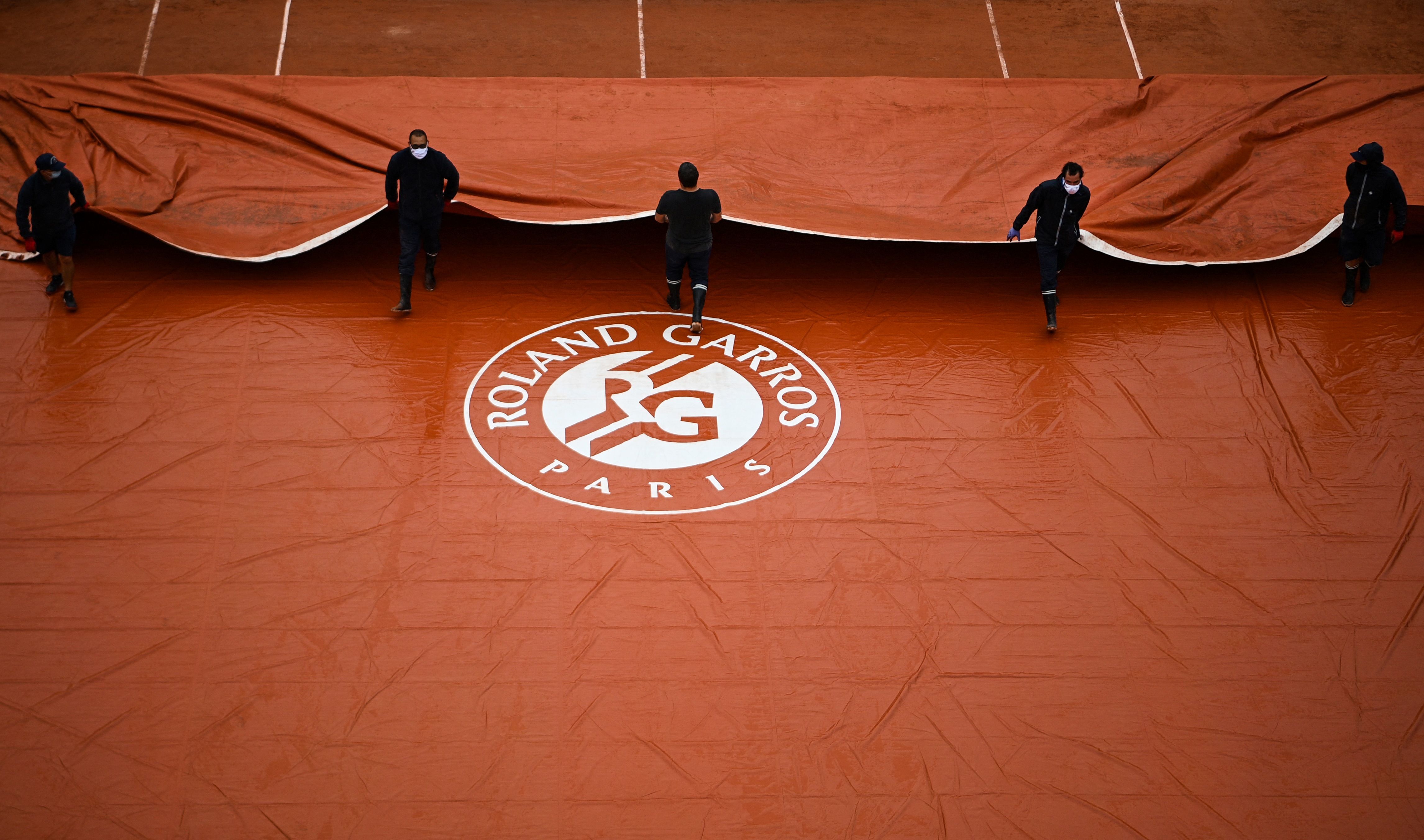 Petugas menutupi lapangan Roland Garros tempat berlangsungnya Prancis Terbuka.