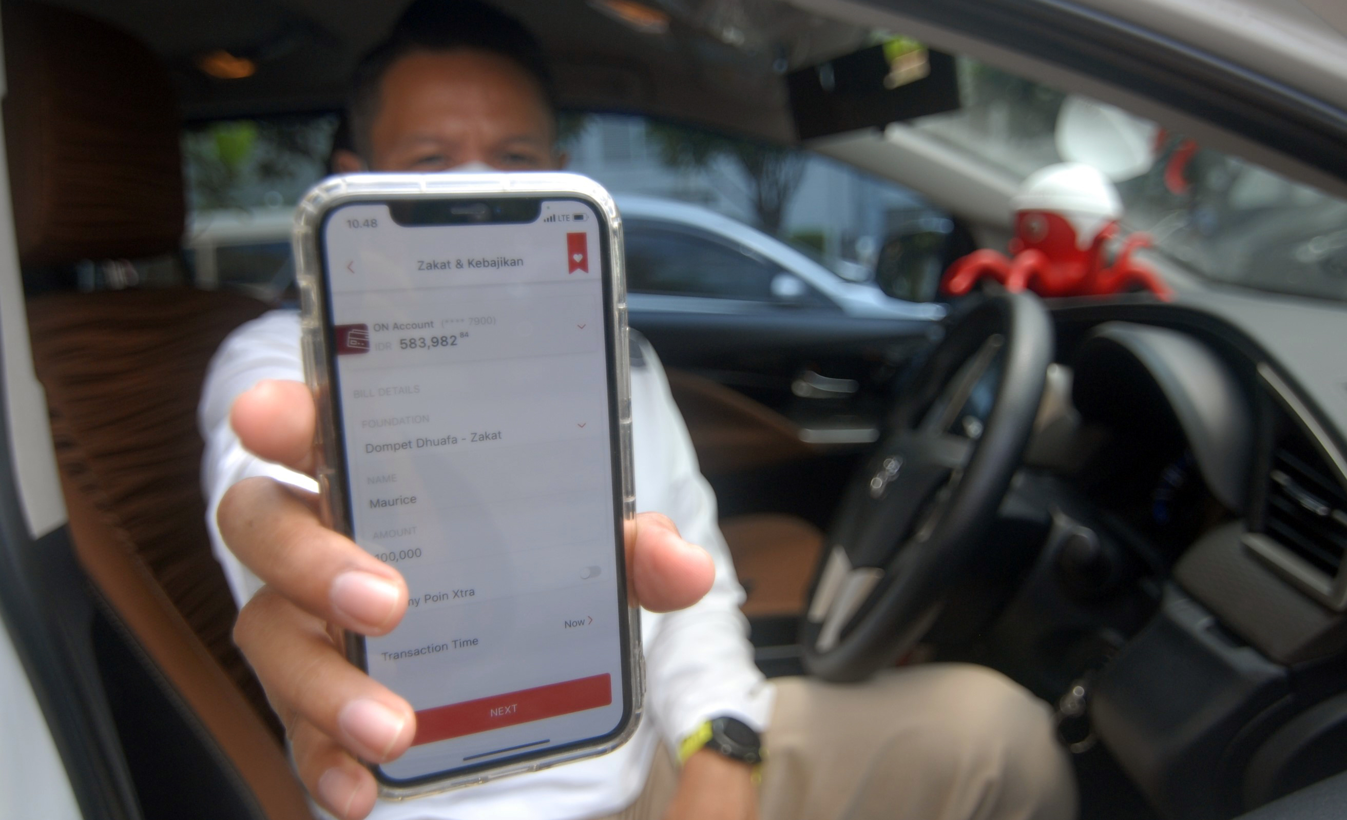 Ilustrasi nasabah melakukan pembayaran zakat menggunakan aplikasi digital banking.