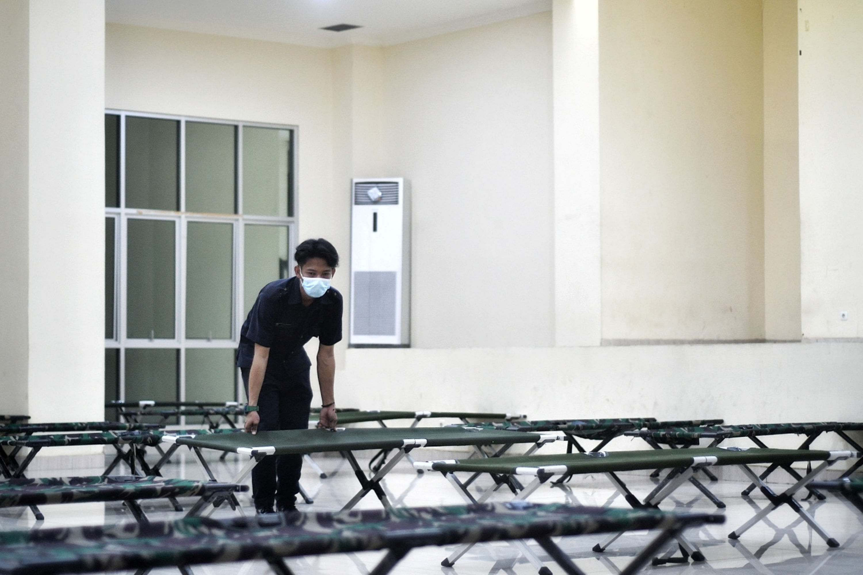 Petugas mengatur jarak velbed di Gelanggang Olahraga (GOR) Tanah Abang untuk isolasi pemudik positif covid-19, Jakarta,Rabu (19/5/2021