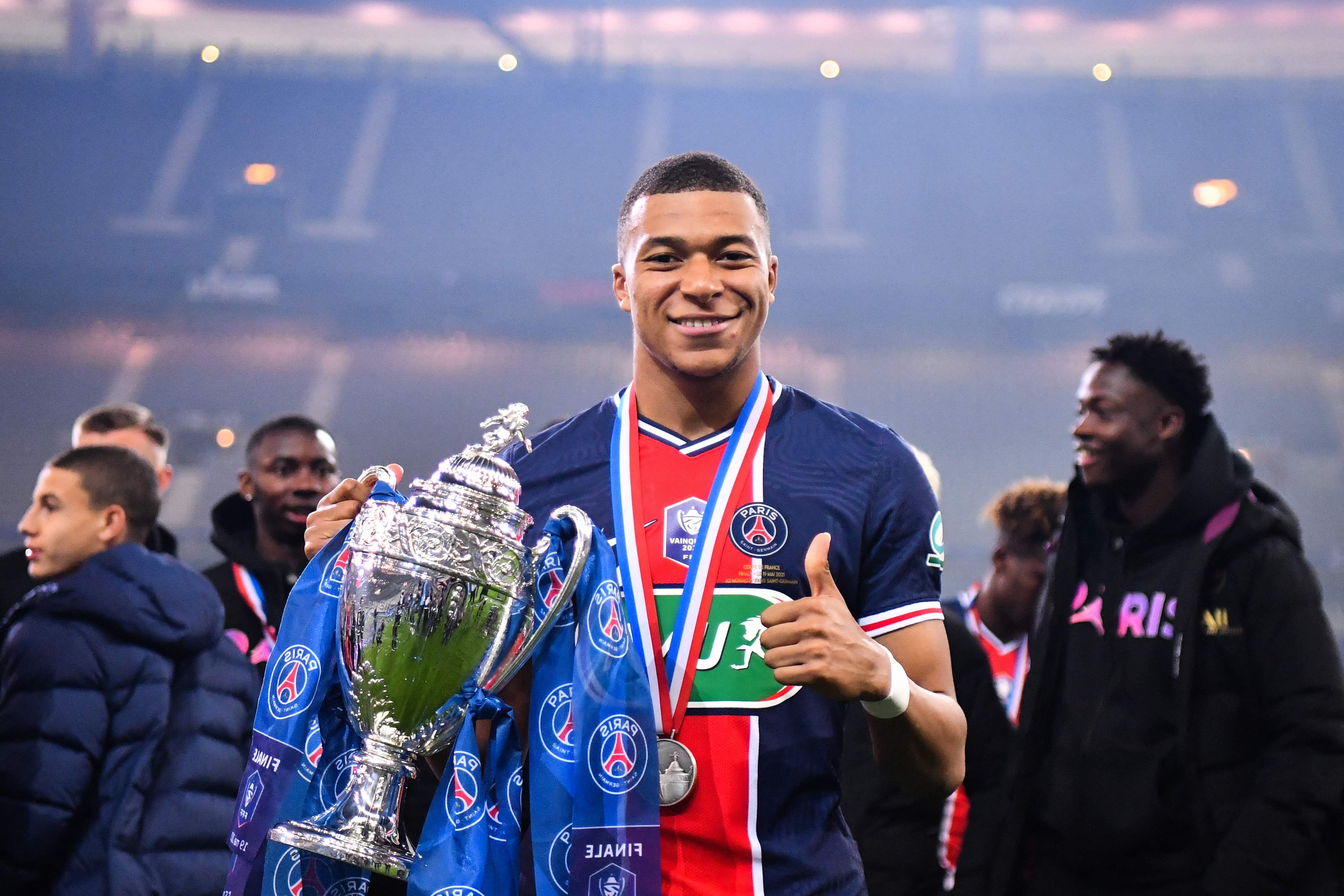 Penyerang PSG Kylian Mbappe merayakan dengan memegang trofi setelah PSG menjuarai Piala Prancis. 