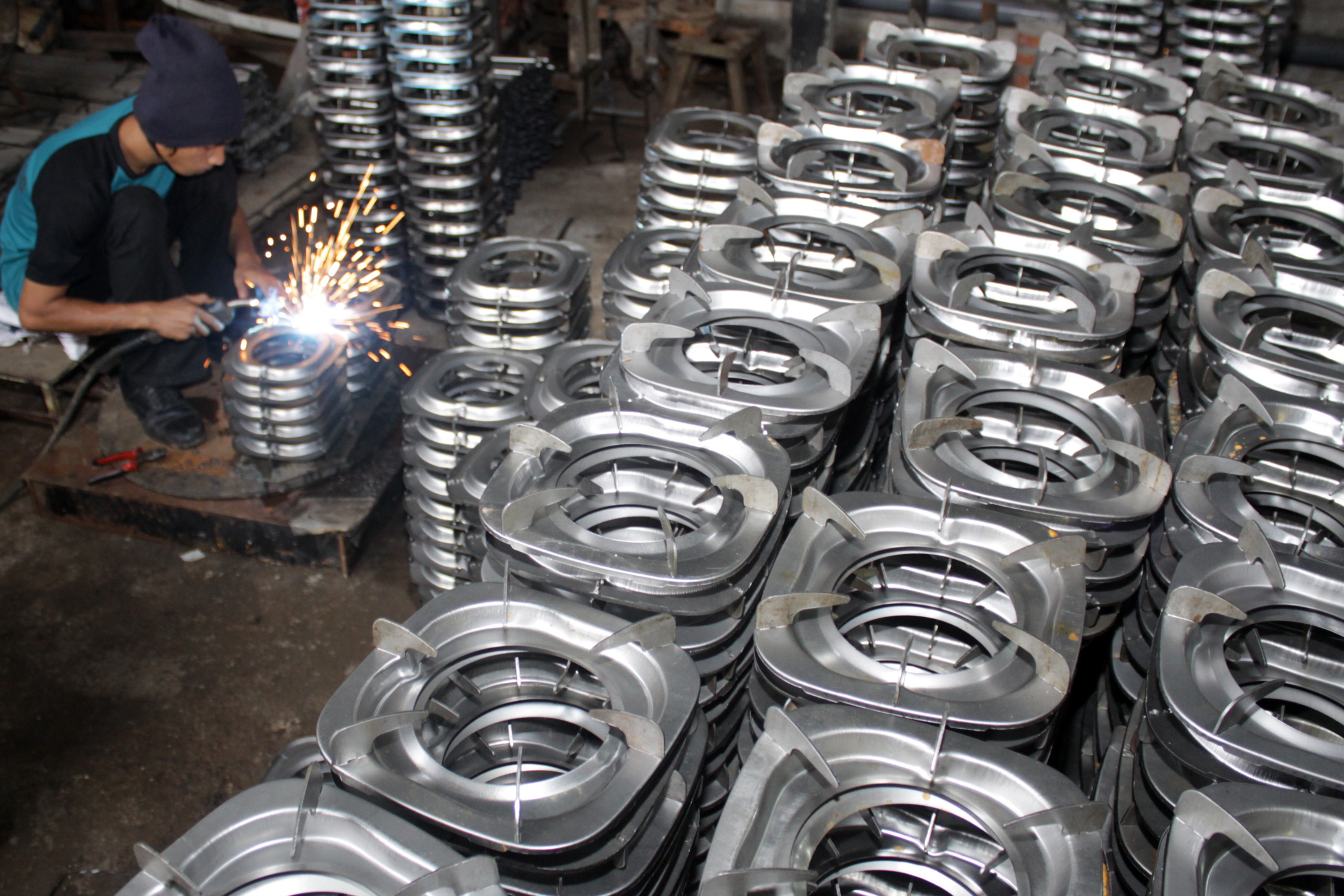 Ilustrasi pekerja menggarap pembuatan tatakan kompor.