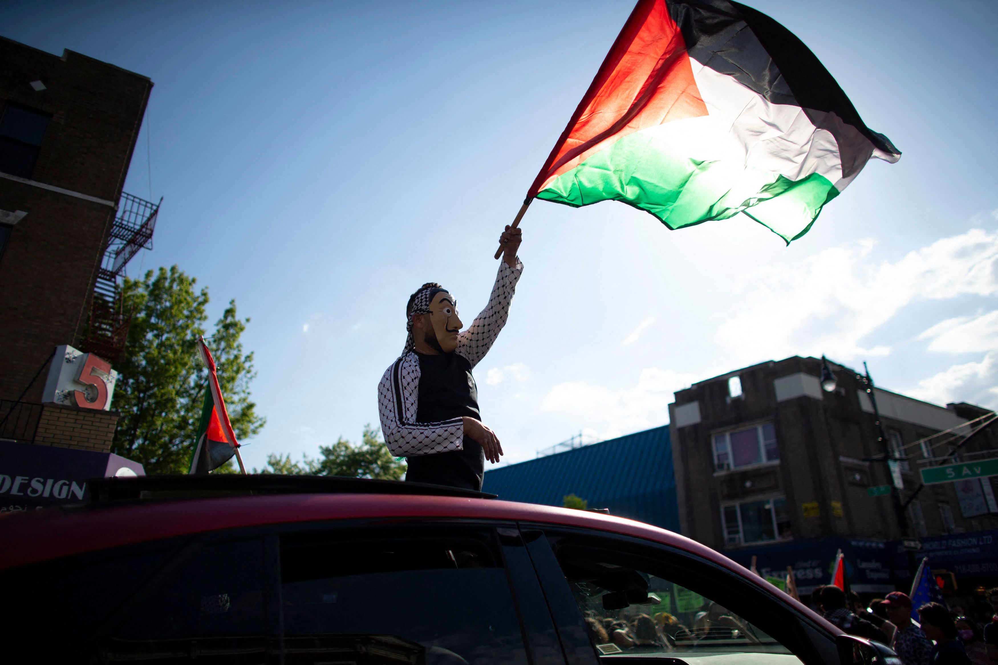 Seorang demonstran mengibarkan bendera Palestina dalam aksi di Brooklyn, New York, AS.