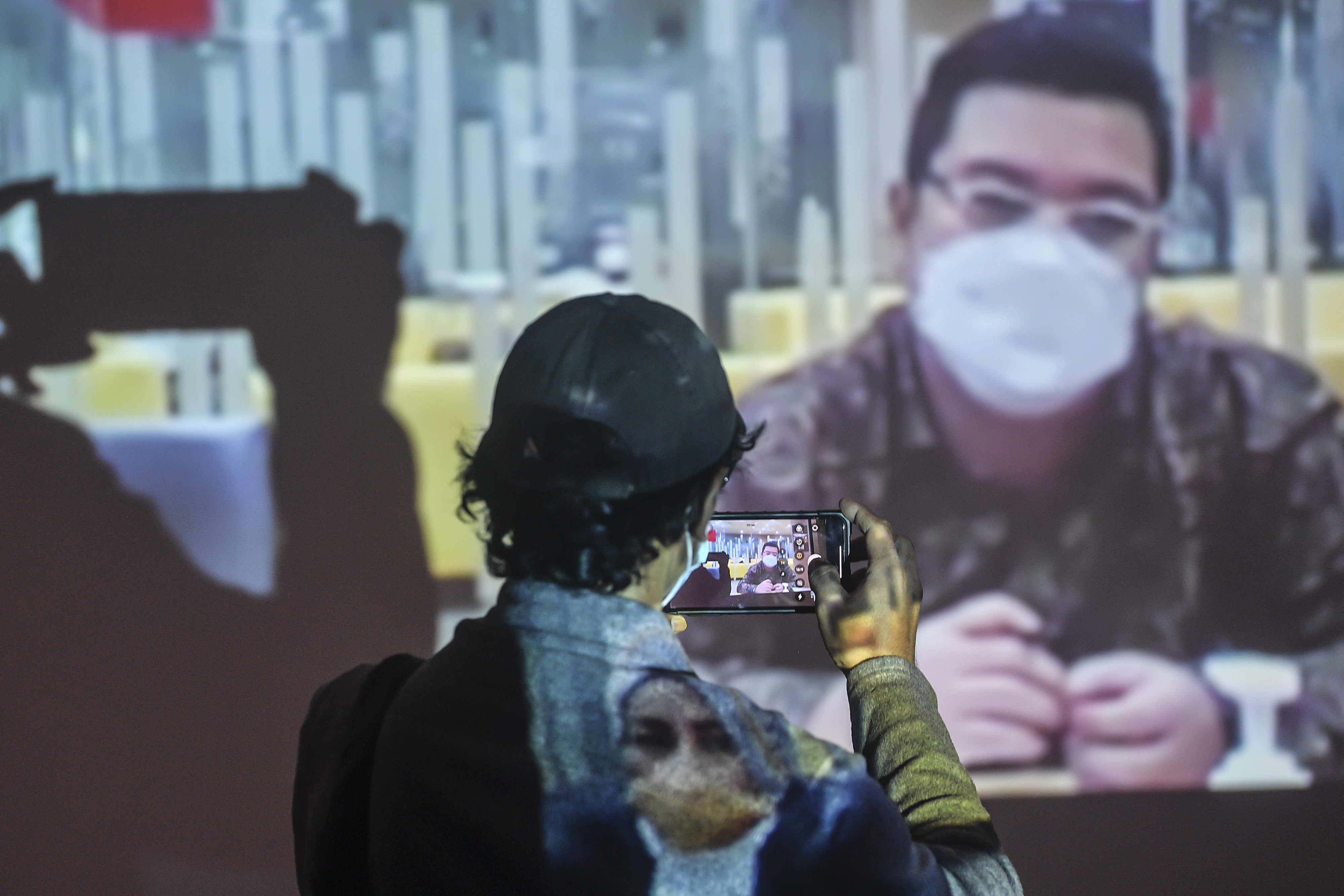 Wartawan mengambil gambar dari layar yang menunjukkan terdakwa Ardian Iskandar Maddanatja di sidang kasus suap bansos Kemensos. 