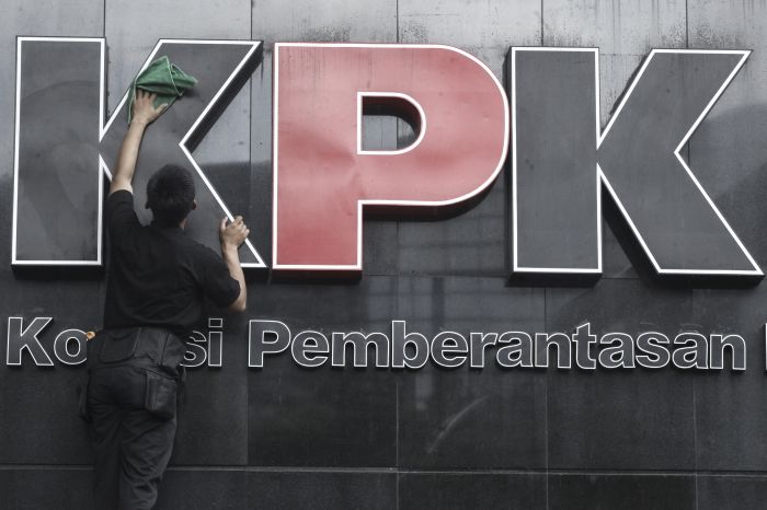Pekerja membersihkan logo KPK di gedung KPK