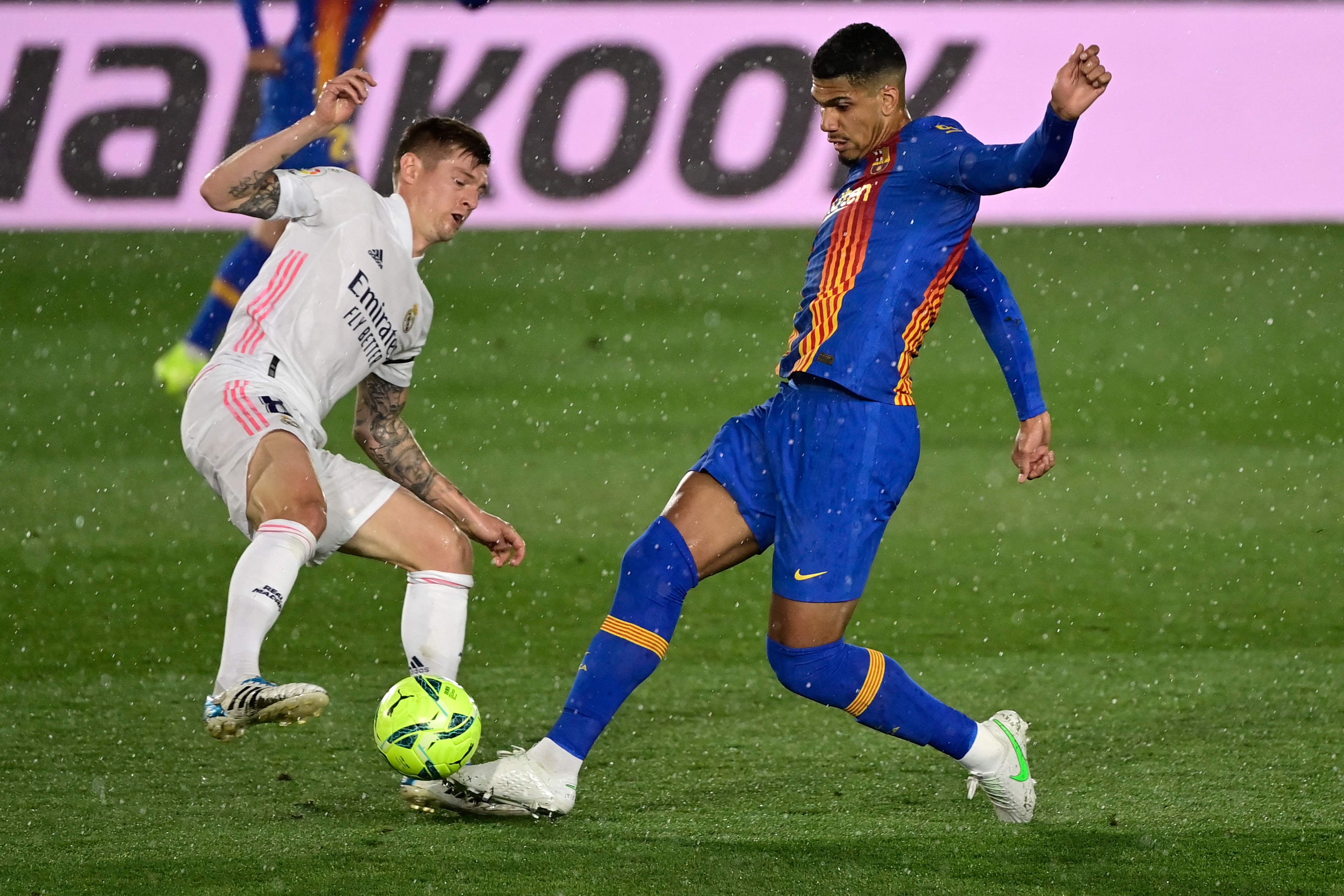 Bak Barcelona asal Uruguay, Ronald Araujo, berusaha merebut bola dari kaki pemain Real Madrid, Toni Kroos.