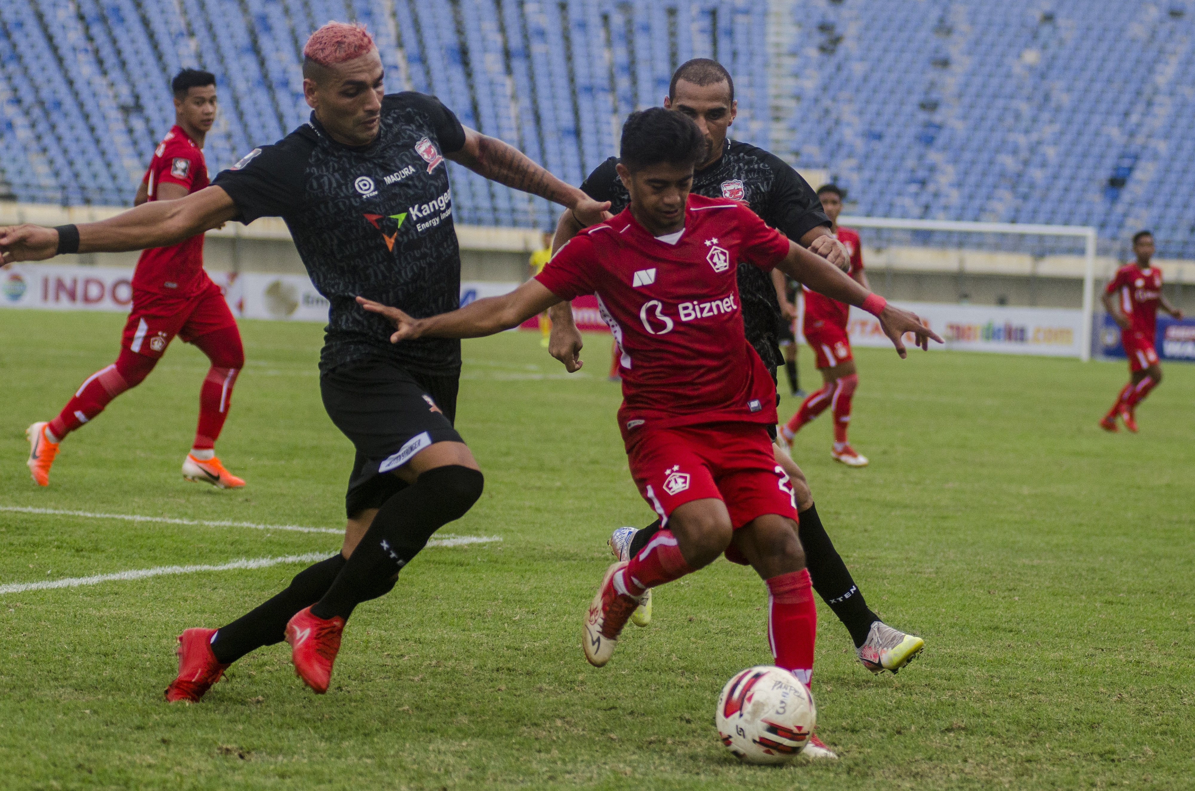 Dua pesepak bola Madura United Jaime Xavier (kiri) dan Bruno Lopes (kanan) berupaya merebut bola dari pemain Persik Kediri Ibrahim Sanjaya.