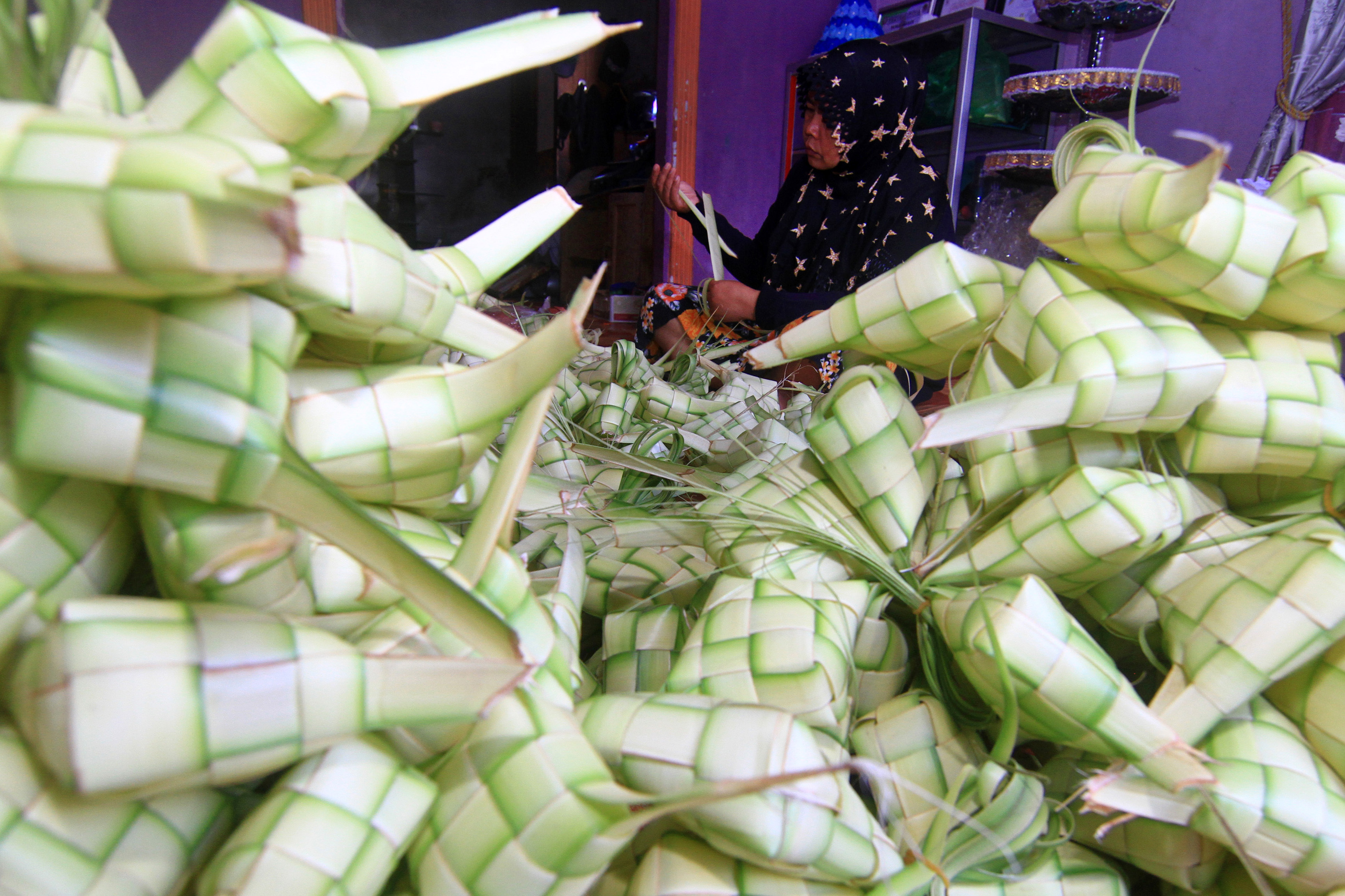 Seorang warga menganyam kulit ketupat pesanan pelanggan di Rumah Rumput Hias, Pontianak, Kalimantan Barat, Rabu (29/7/2020). 