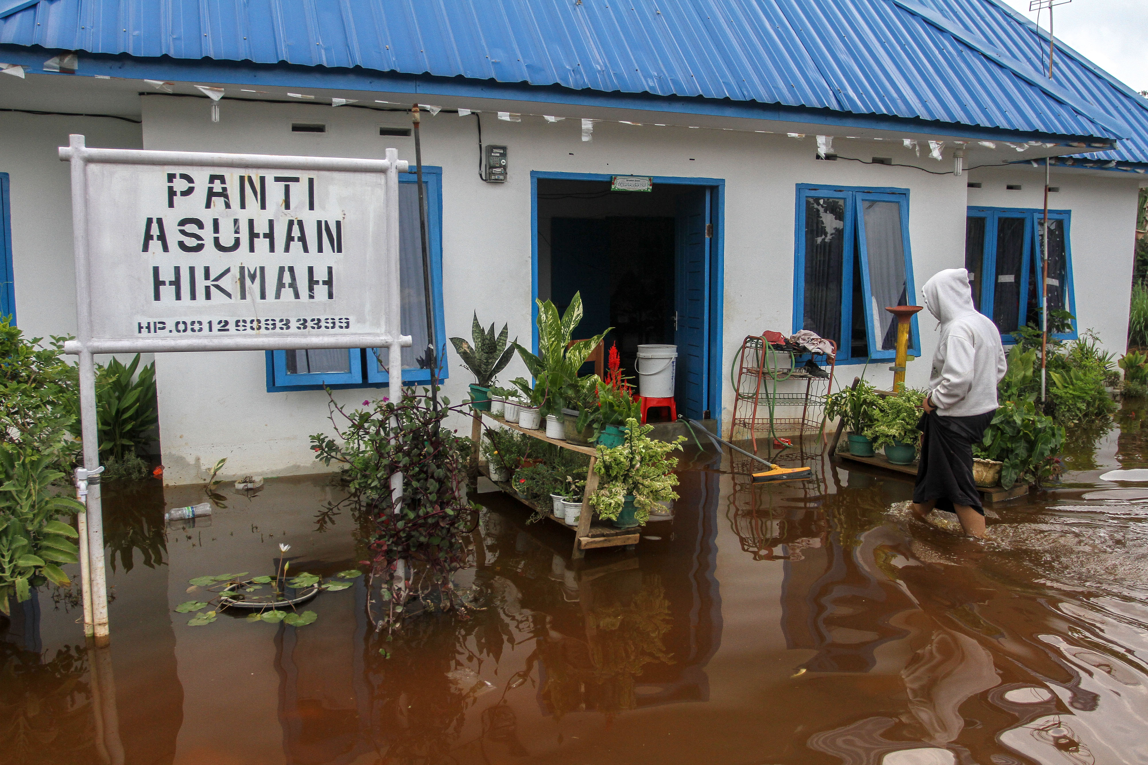 Seorang anak penghuni Panti Asuhan Hikmah berjalan menuju ke dalam panti yang terendam banjir di Pekanbaru, Riau, Rabu (28/4).