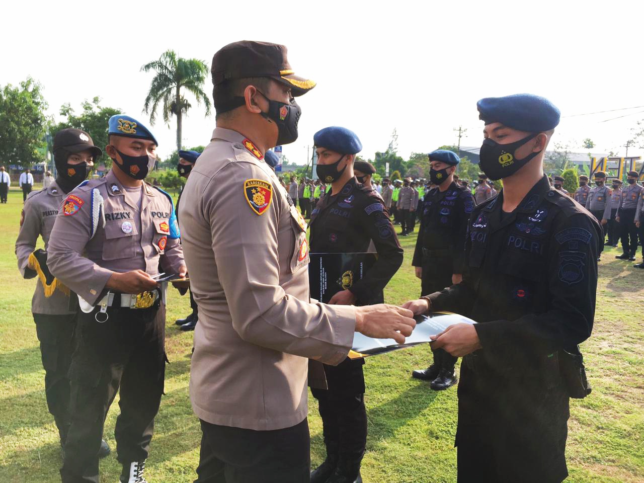 Kapolres AKB Edy Suranta Sitepu menyerahkan penghargaan kepada salah satu anggota Brimob.