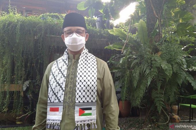 Gubernur DKI Anies Baswedan berpose menggunakan sorban berbendera Palestina dan bendera Merah Putih di rumahnya di Lebak Bulus, Jaksel.
