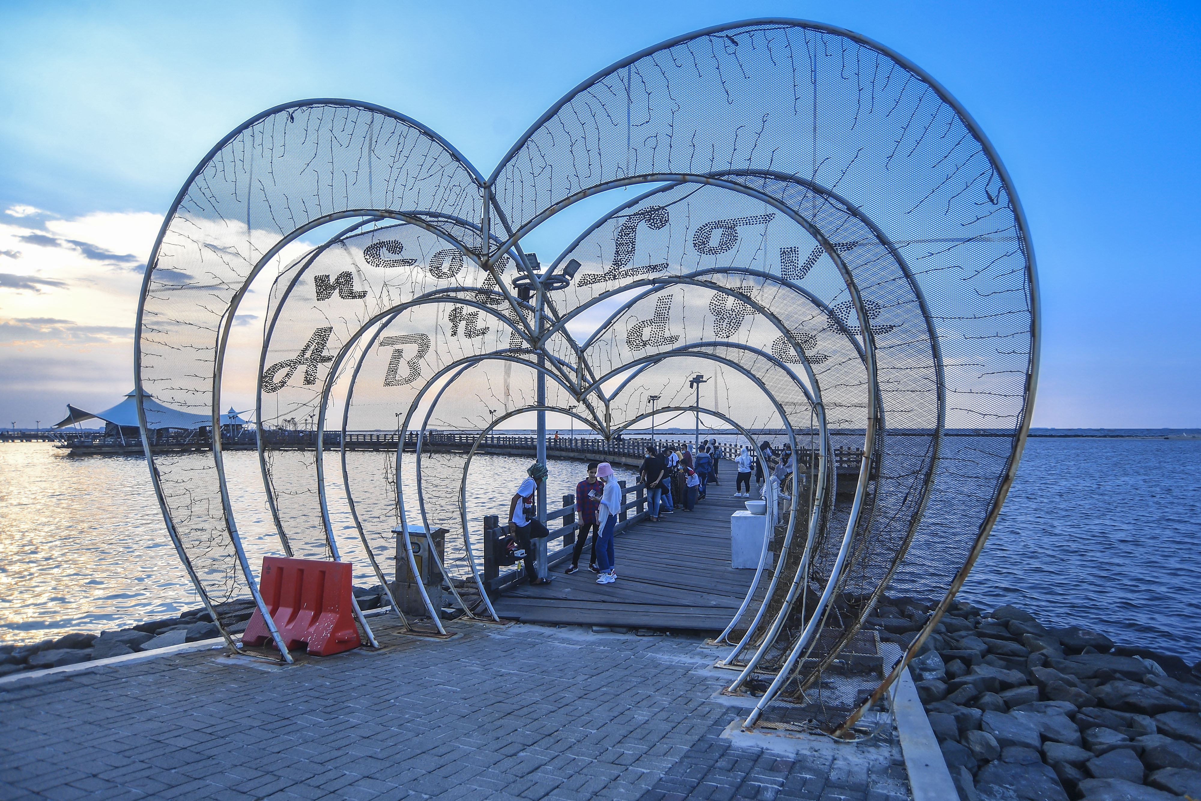 Wisatawan berada di jembatan cinta di kawasan pantai Ancol, Jakarta, akhir pekan lalu.