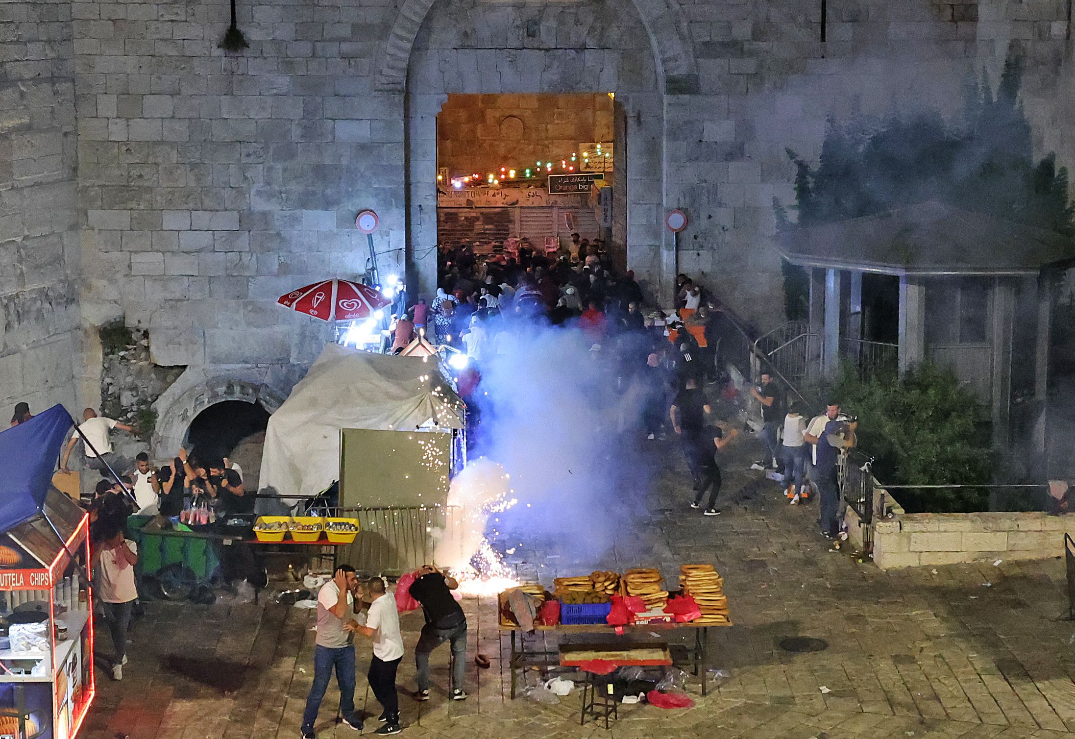 Demonstran Palestina melarikan diri setelah polisi Israel menembakkan flashbang ke arah mereka.