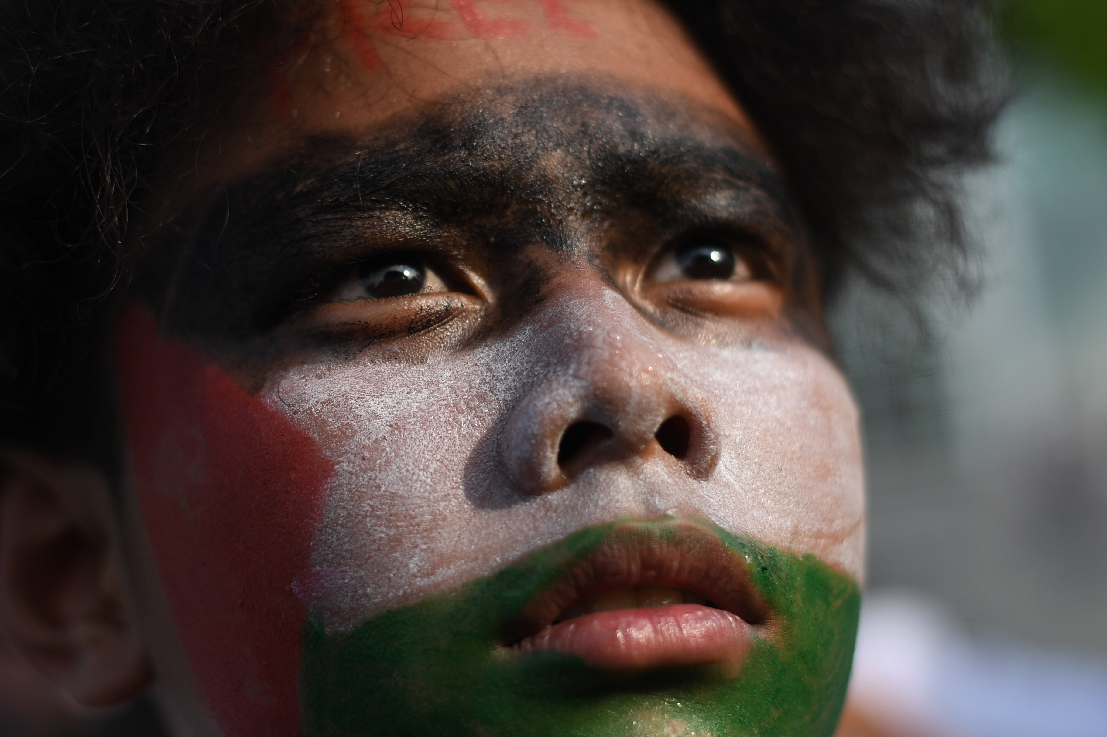 Seorang pengunjuk rasa melukis wajah dengan bendera Palestina saat mengikuti aksi di depan Gedung Kedubes Amerika Serikat, Jakarta, Selasa