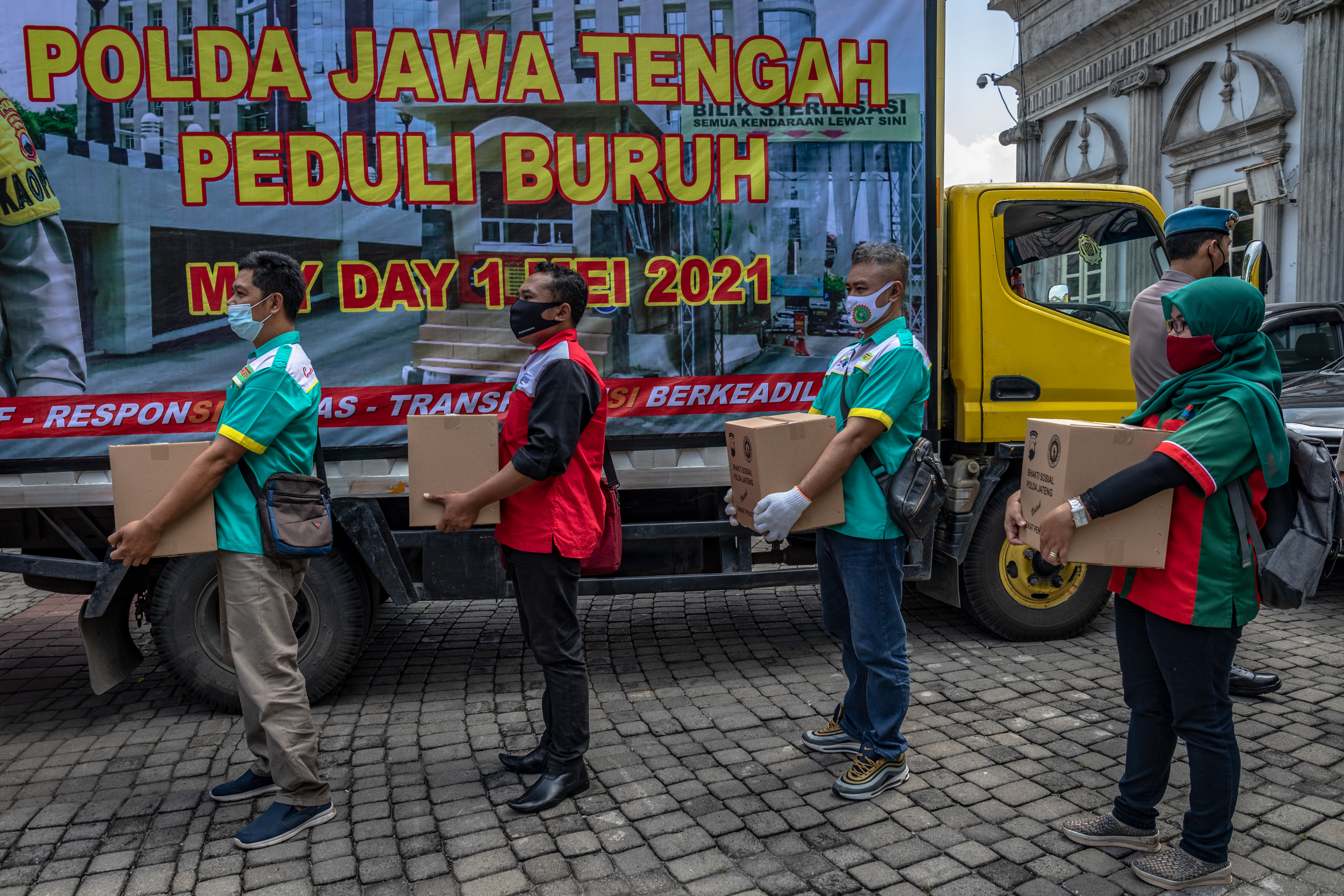 Sejumlah buruh menerima paket sembako dari Polda Jawa Tengah seusai mengikuti dialog pada Hari Buruh.