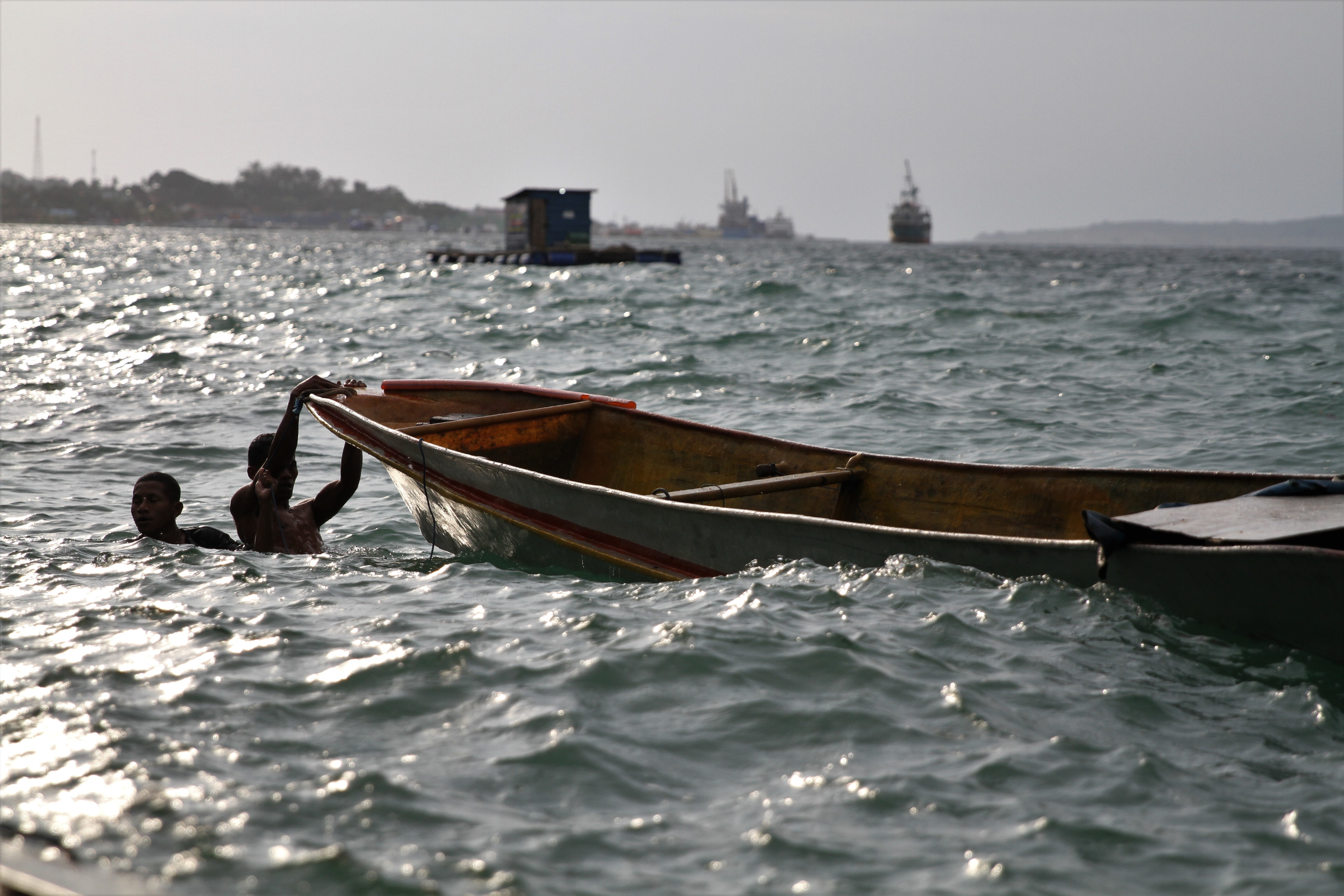 WASPADA GELOMBANG TINGGI: Nelayan menarik perahunya setelah terseret ombak di Perairan Baubau, beberapa waktu lalu.