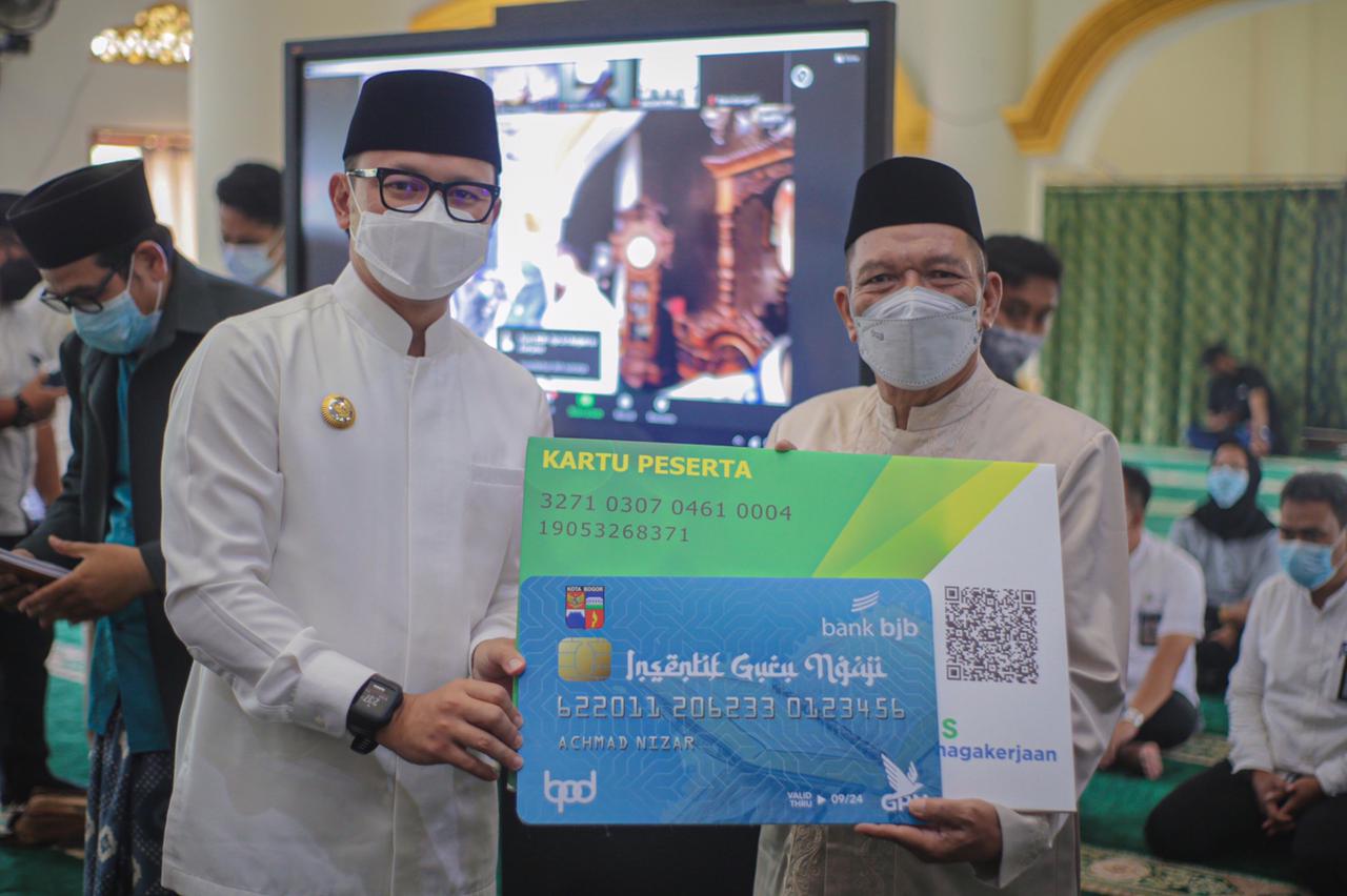 Wali Kota Bogor menyerahkan secara simbolis kartu kepersertaan BPJS Ketenagakerjaan kepada guru ngaji di Kota Bogor, Rabu (5/5/2021).