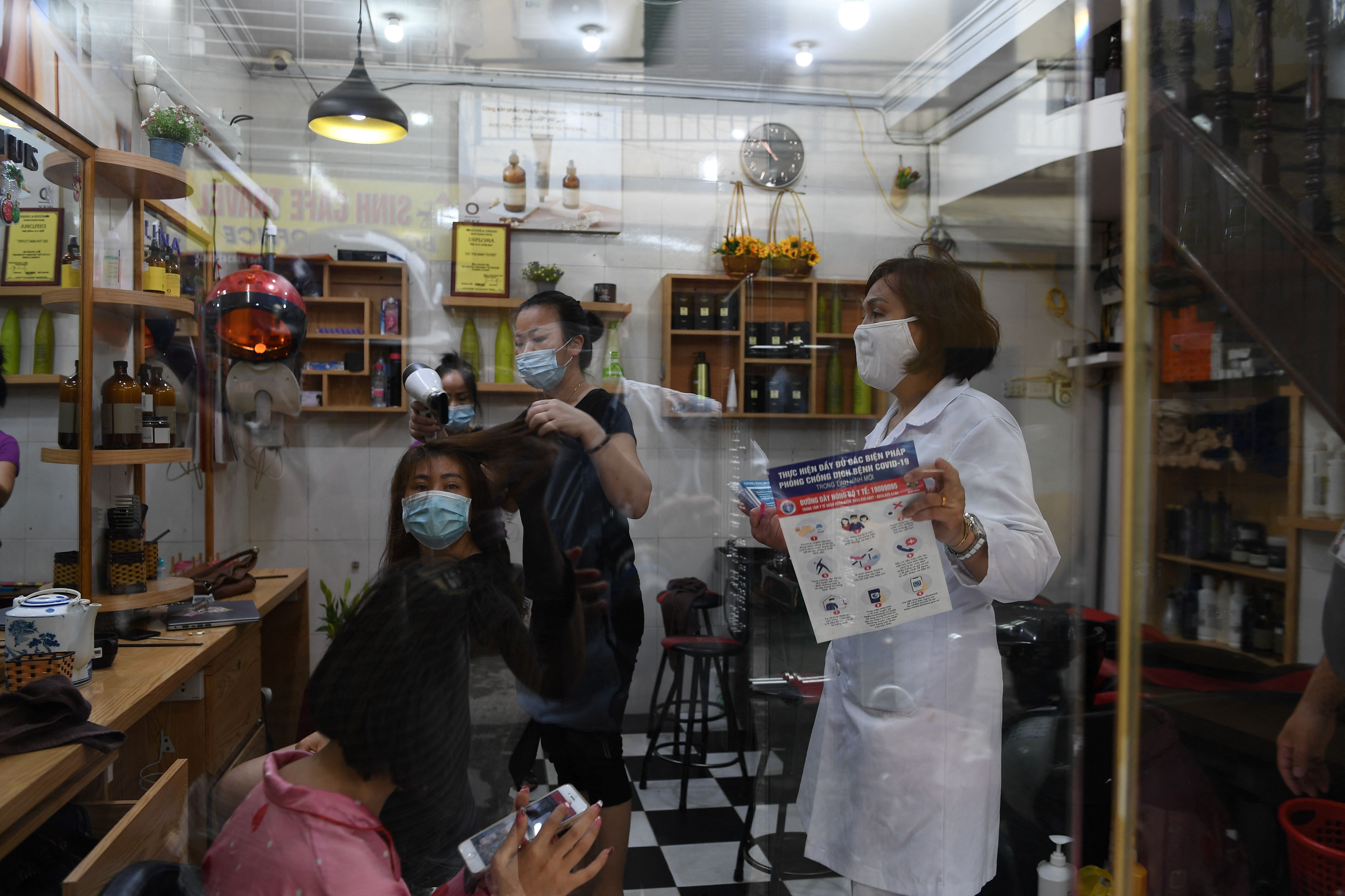 Seorang petugas kesehatan meminta sebuah salon di Hanoi untuk tutup seiring meningkatnya kasus covid-19 di Vietnam.