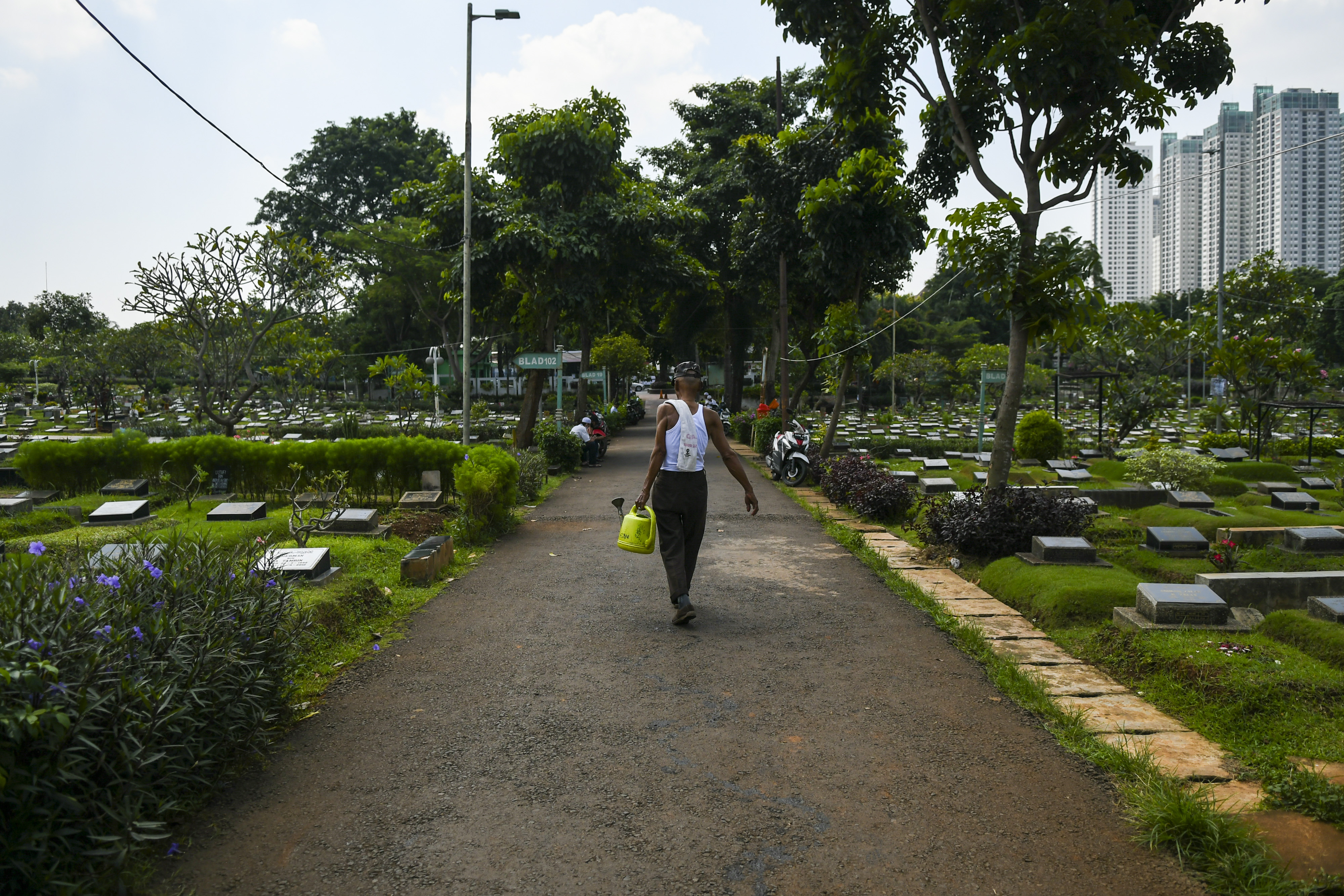 Petugas menyiram tanaman di TPU Karet Bivak, Jakarta