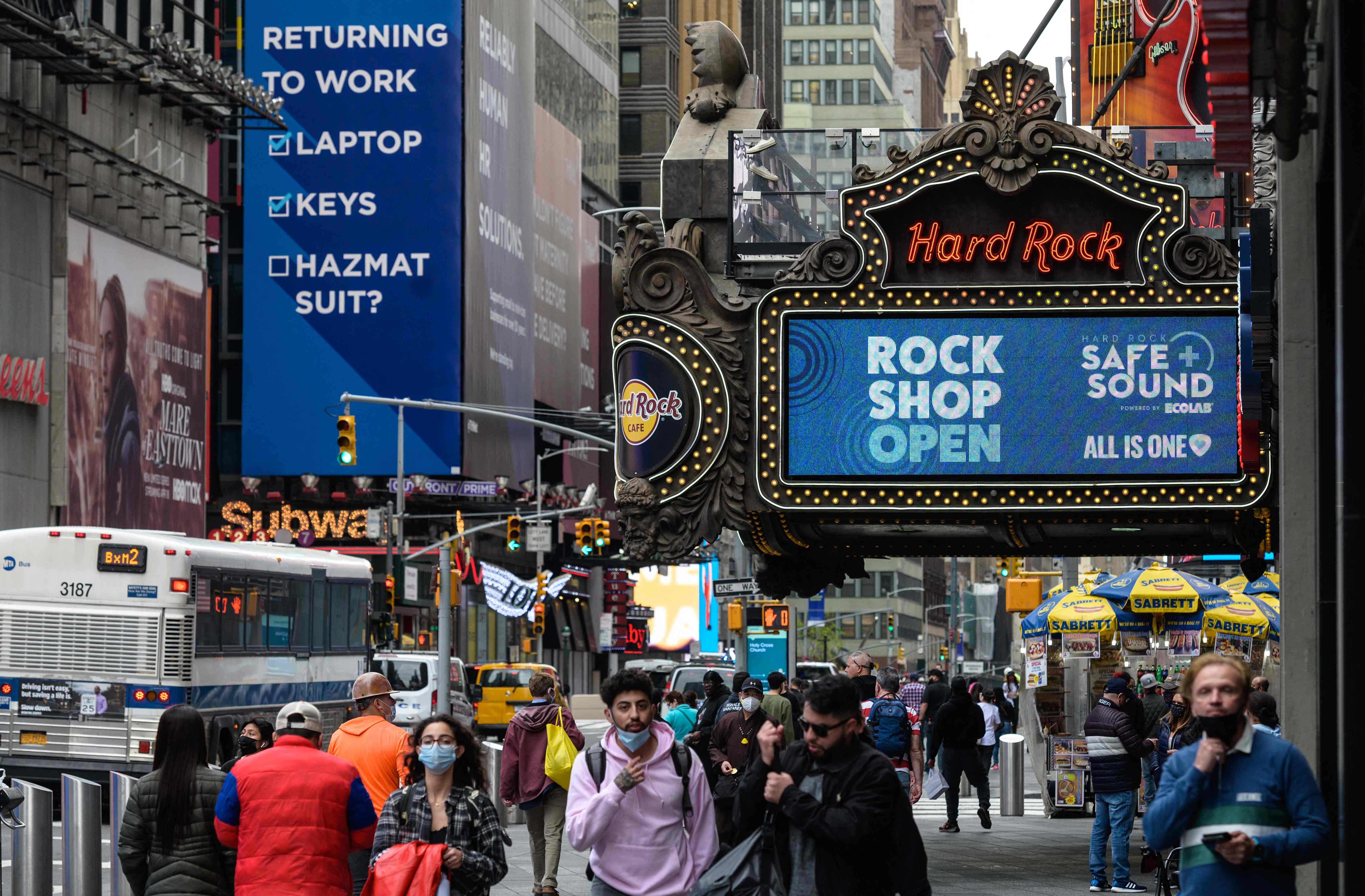 Sejumlah orang melintasi Hard Rock Cafe yang sudah beroperasi di Kota New York, AS, Senin (3/5) sejak dilakukan pelonggaran sosial.
