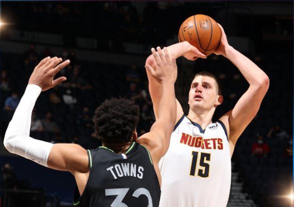 Pemain Denver Nuggets Nikola Jokic (kanan) melepaskan tembakan dalam laga NBA melawan Minnesota Timberwolves.