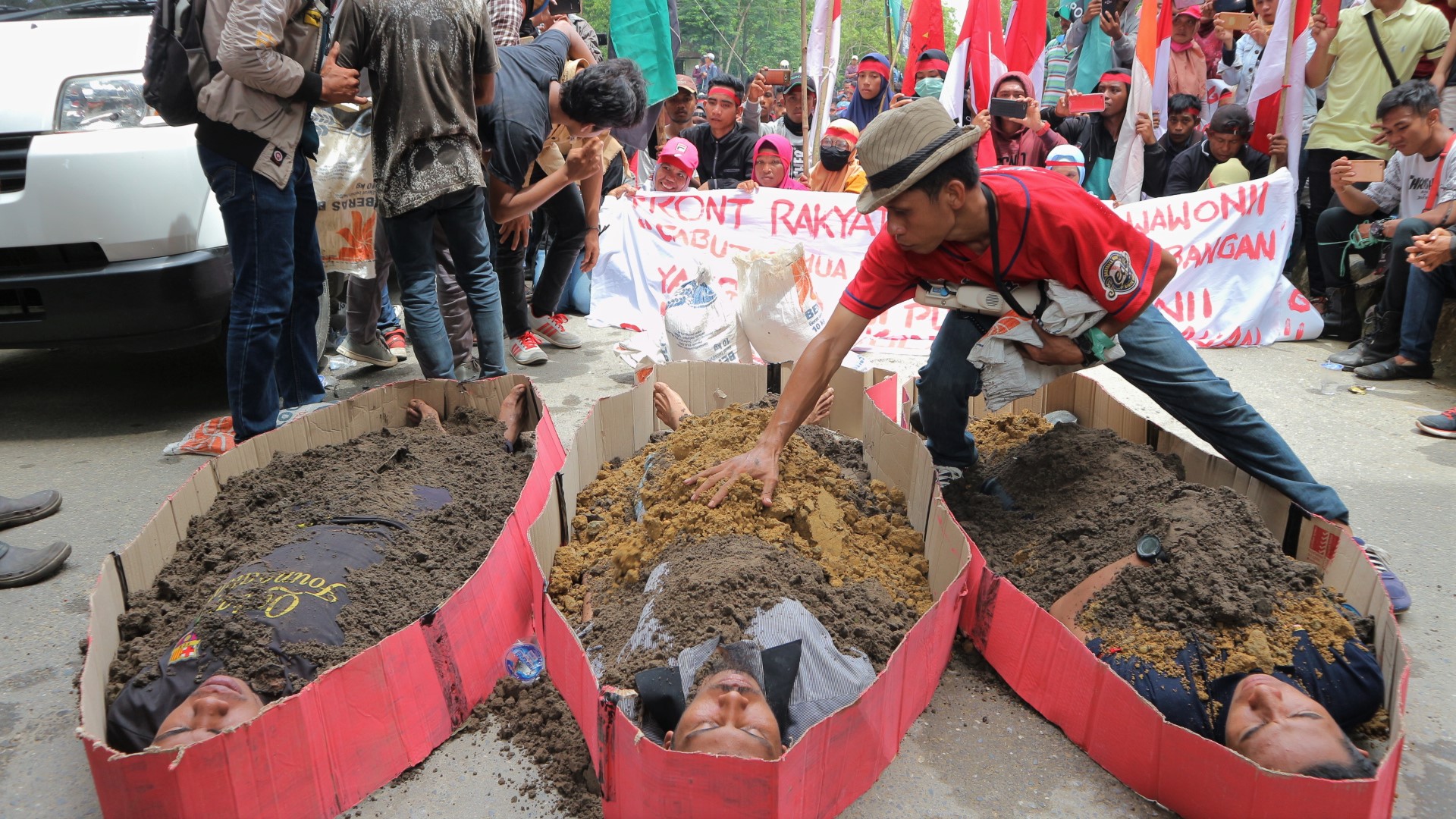   Warga melakukan aksi teatrikal dengan cara mengubur diri saat aksi demonstrasi menolak tambang di depan Kantor Gubernur Sulawesi Tenggara.